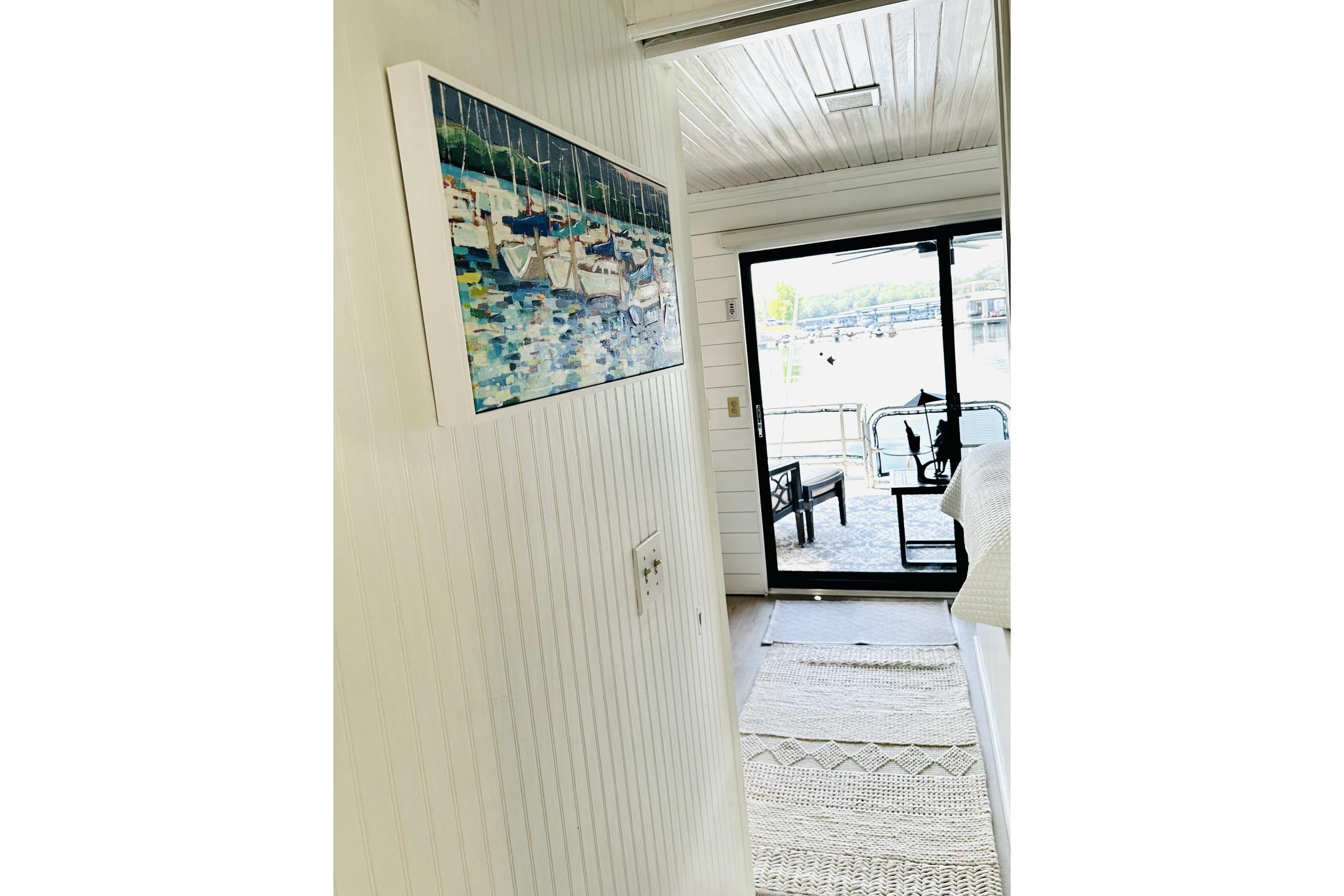 Interior of 1992 Sumerset 66 houseboat with artwork and lake view through glass door.