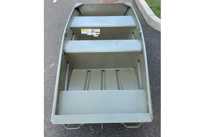 2026 Tracker Grizzly 10 Jon boat on pavement, showcasing interior seating and structure.