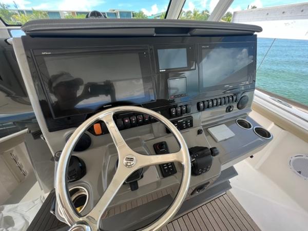 2019 Pursuit S 408 Sport boat helm with steering wheel and navigation screens.