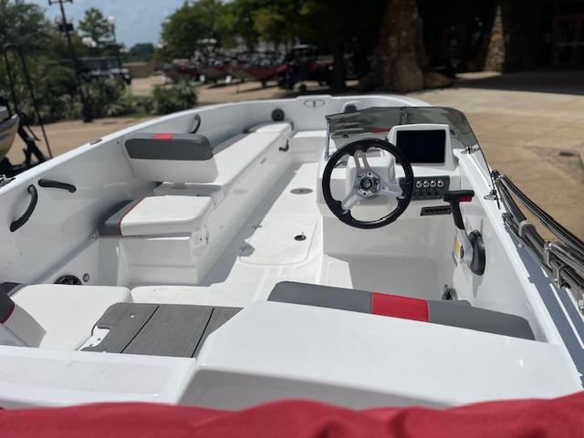 2024 Tahoe T18 boat interior with steering wheel and seating, docked outdoors.