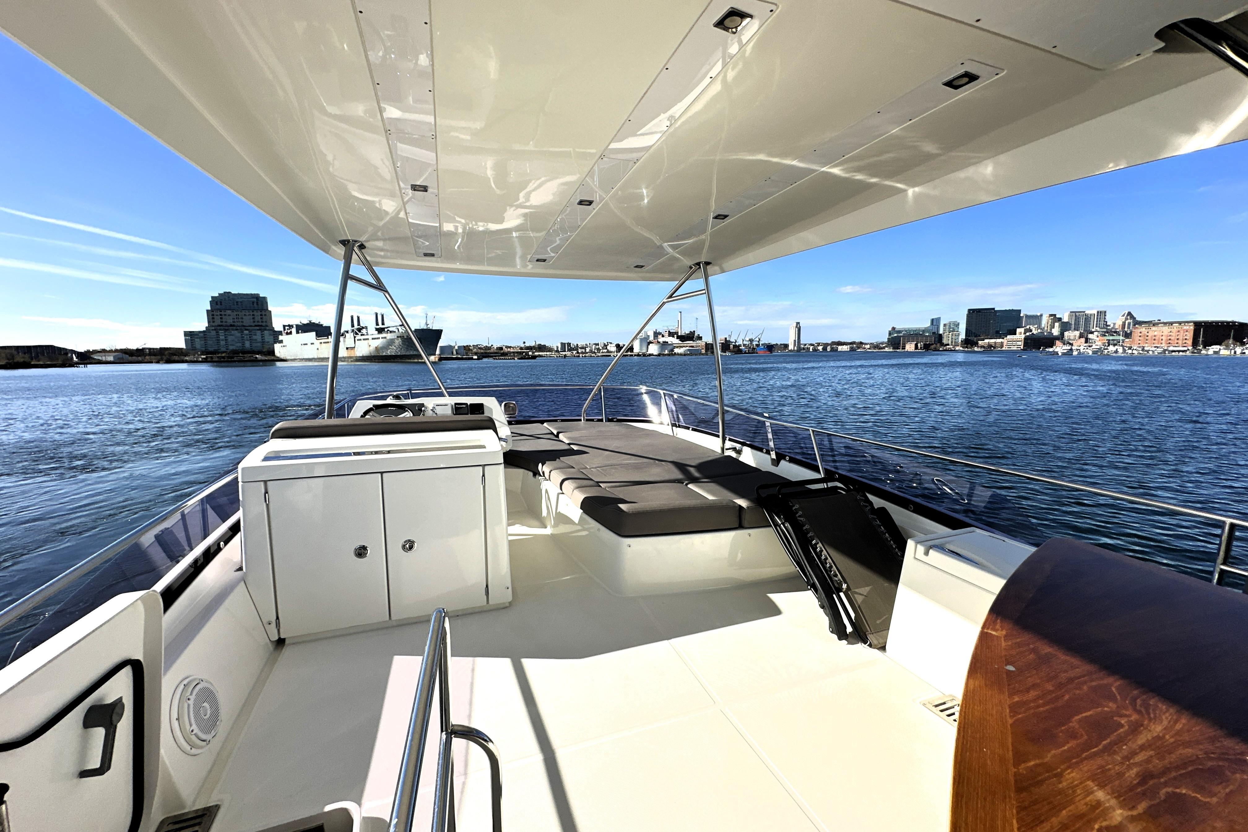 Luxurious 2016 Prestige 550 yacht deck with city skyline view.