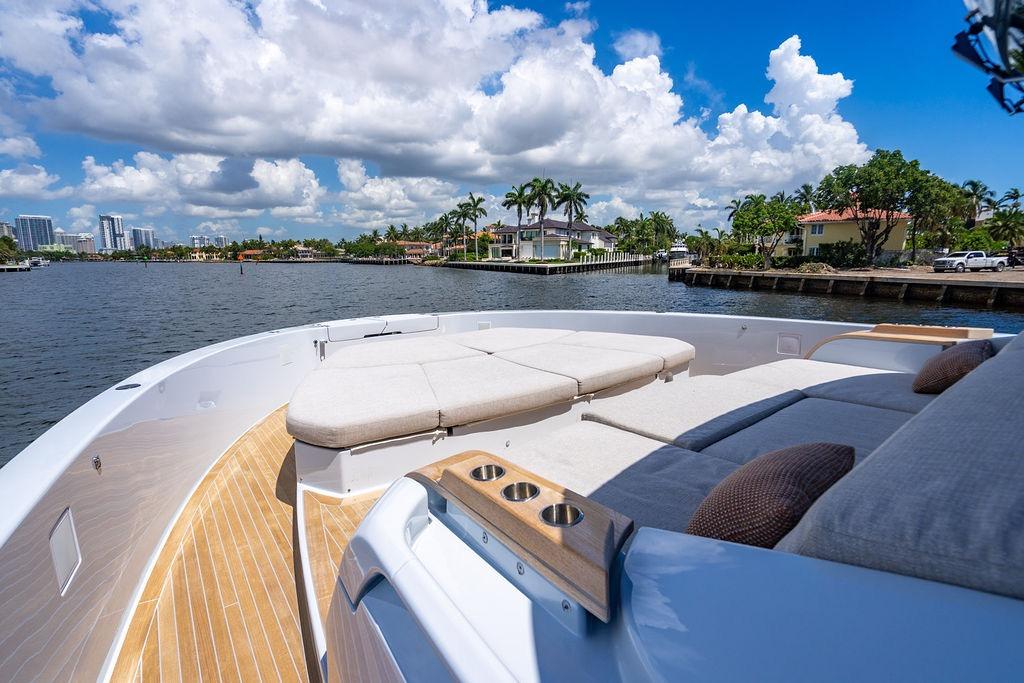 Luxurious 2023 Bluegame BG 72 yacht with spacious deck and scenic waterfront view.