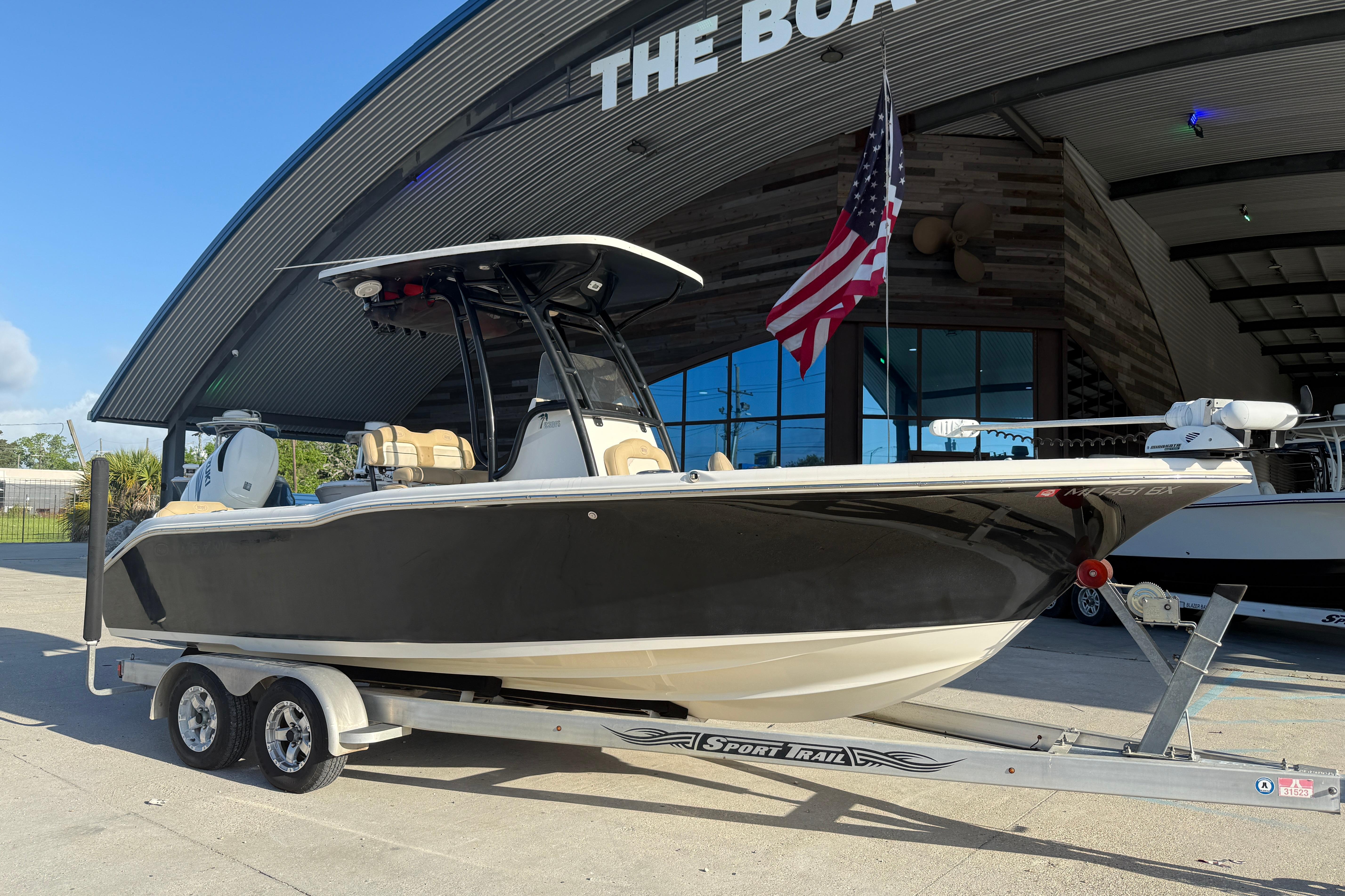 2016 Key West 239 FS boat on trailer outside a showroom with American flag.