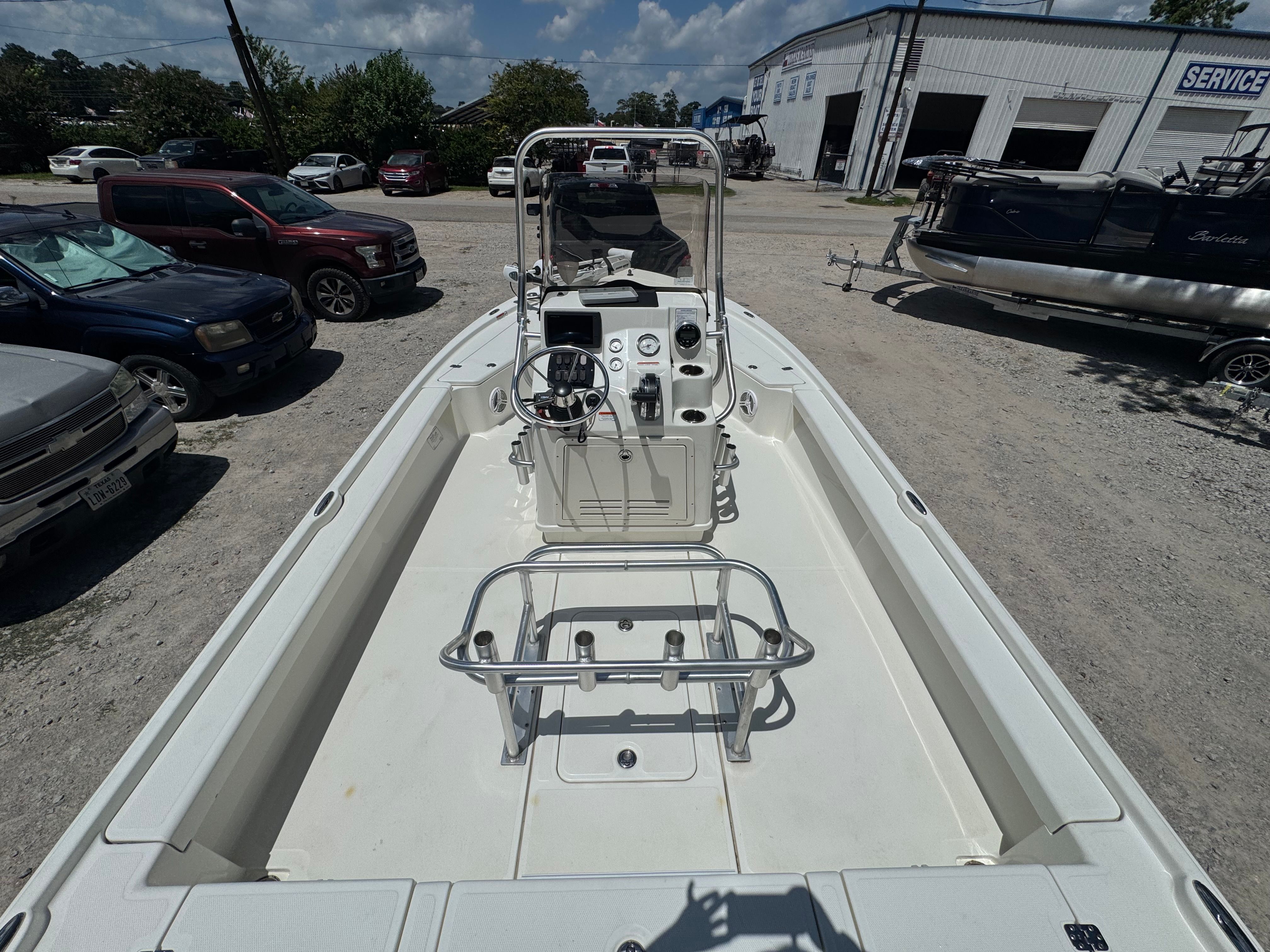 2014 Mako 21 LTS boat parked among vehicles in a lot.