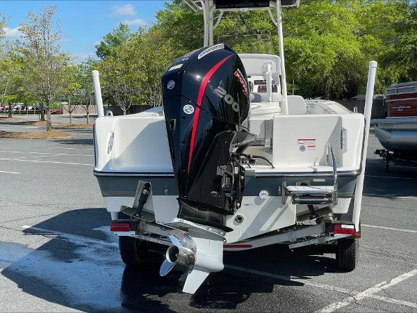 2024 Mako 214 CC boat with powerful outboard motor in parking lot.