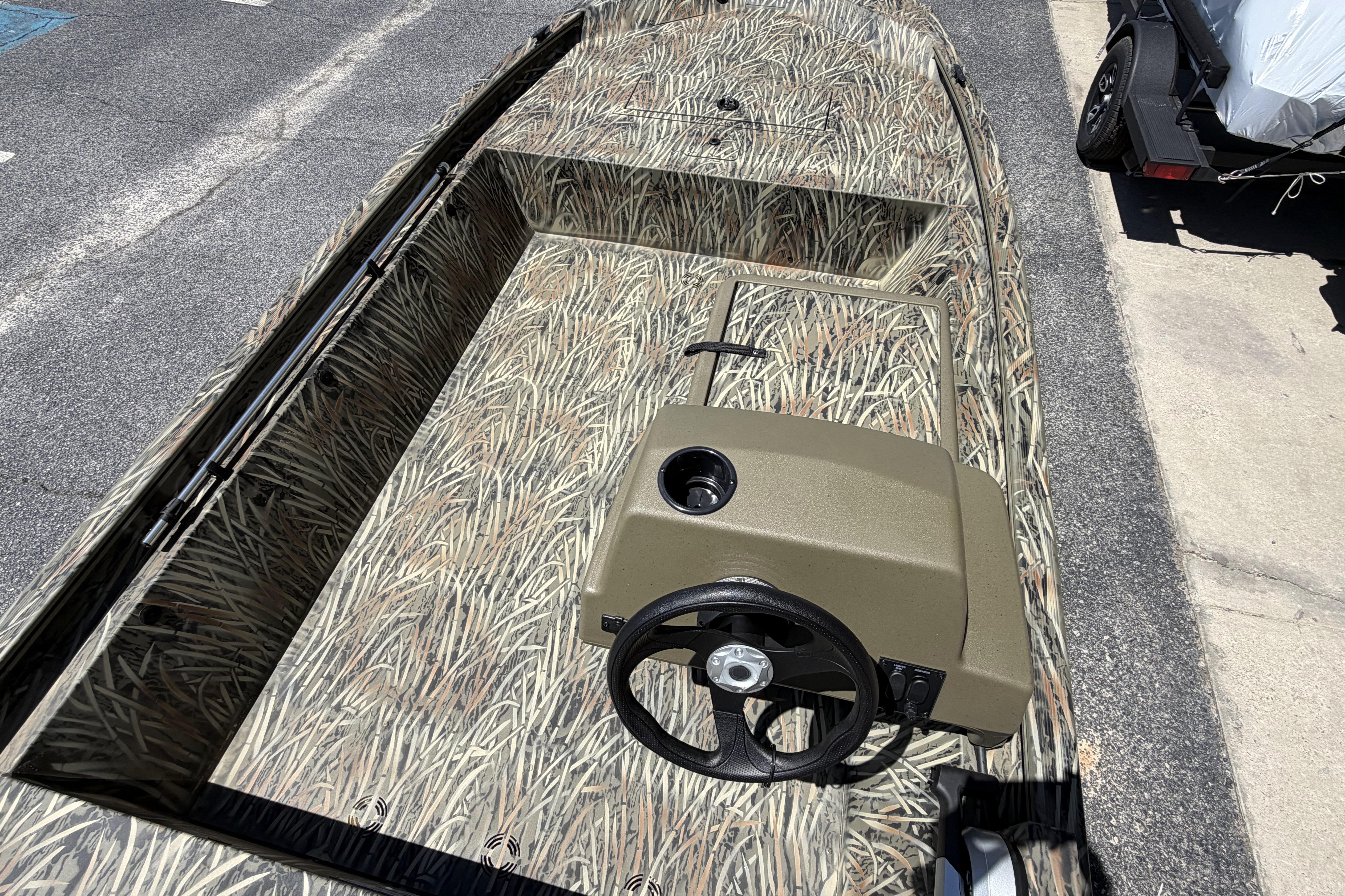 2026 Tracker Grizzly 1648 SC boat with camouflage interior and steering console.