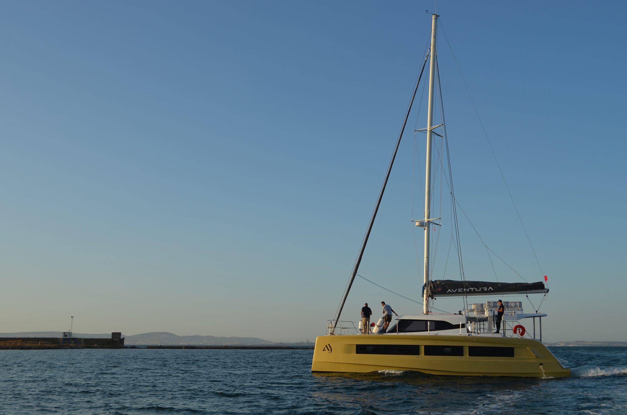 Aventura 45 catamaran sailing on calm waters under a clear blue sky, 2026 model.