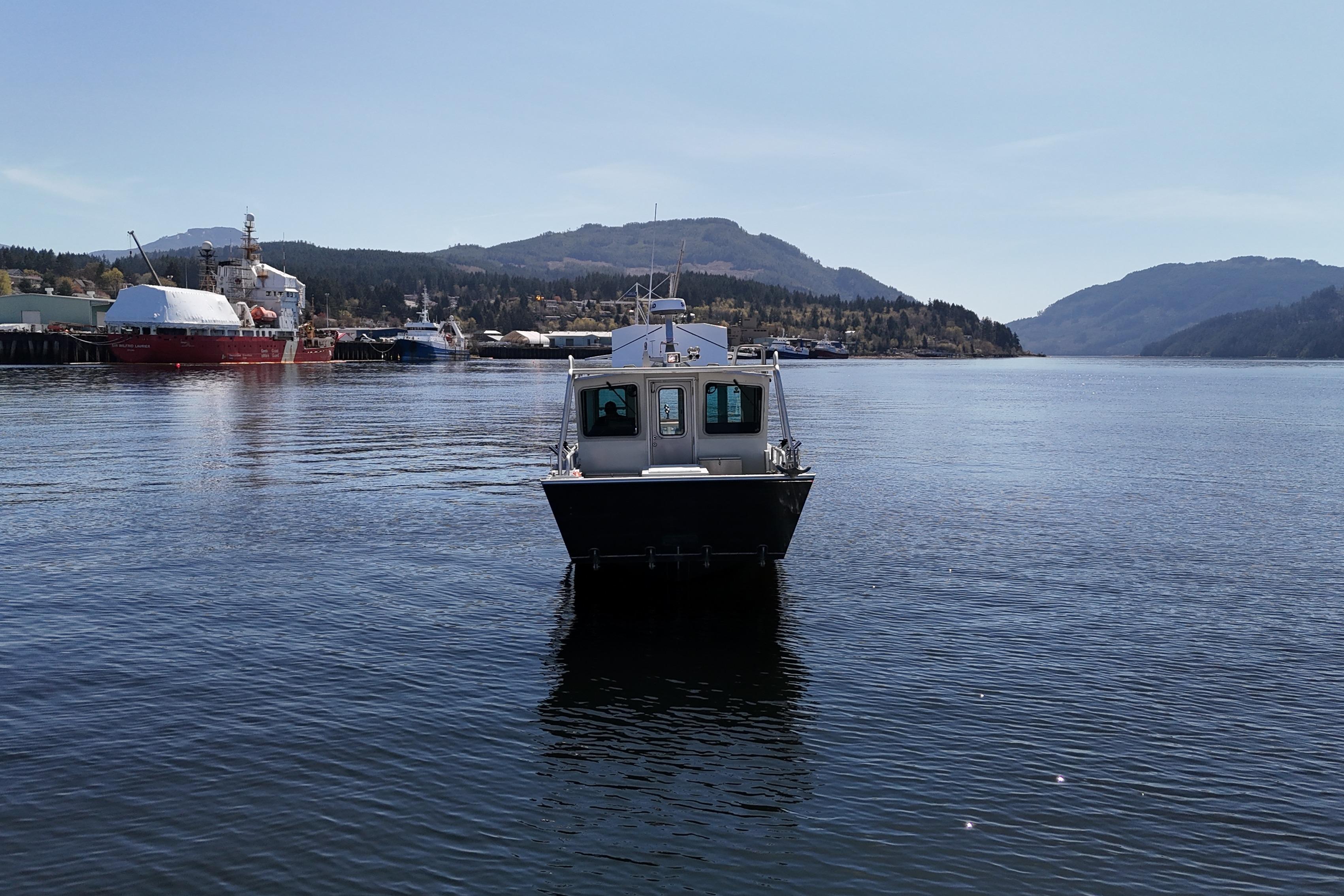 2021 Silver Streak 32 Landing Craft Cabin on calm water with scenic mountain backdrop.