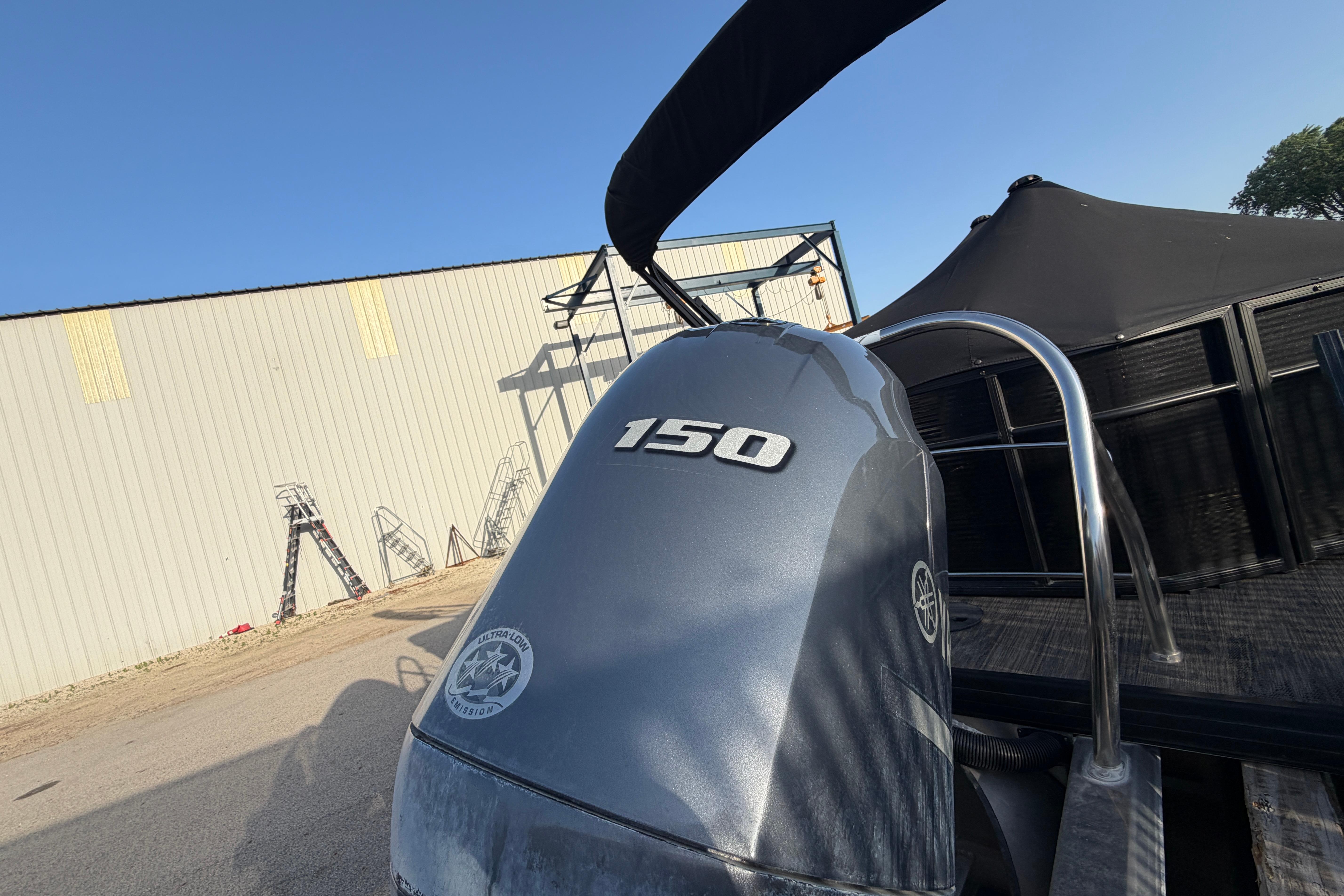 2023 Godfrey Sweetwater 2286 C boat with 150 horsepower engine, docked outdoors.