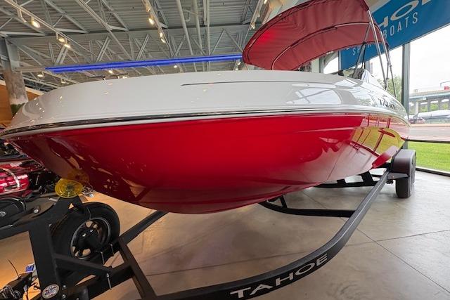 2026 Tahoe T21 boat with red hull on display in showroom.