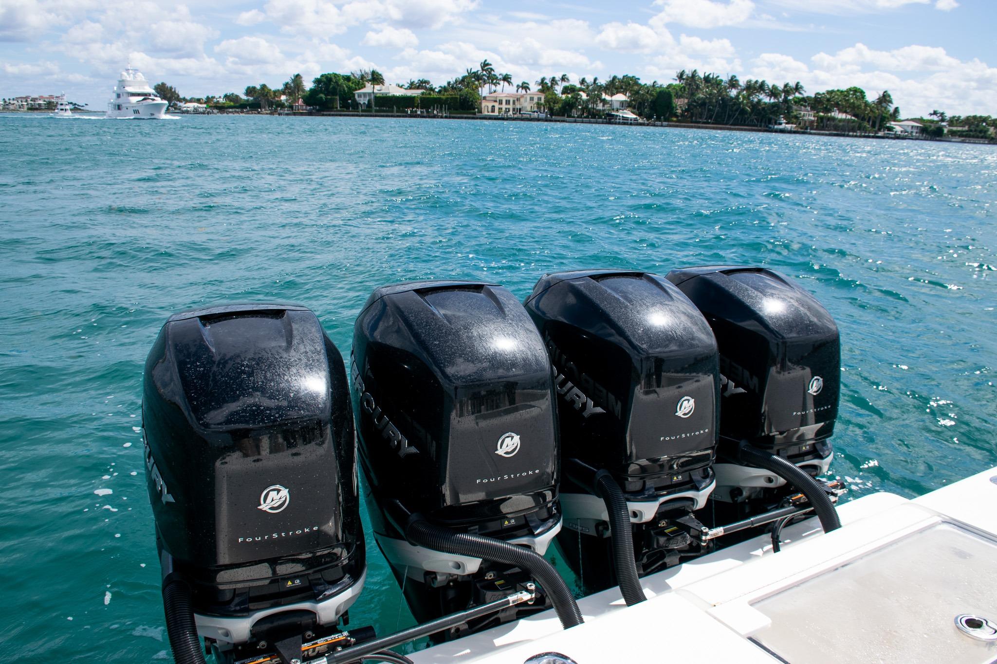 Four powerful outboard engines on a 2022 SeaVee 390Z boat in clear blue waters.