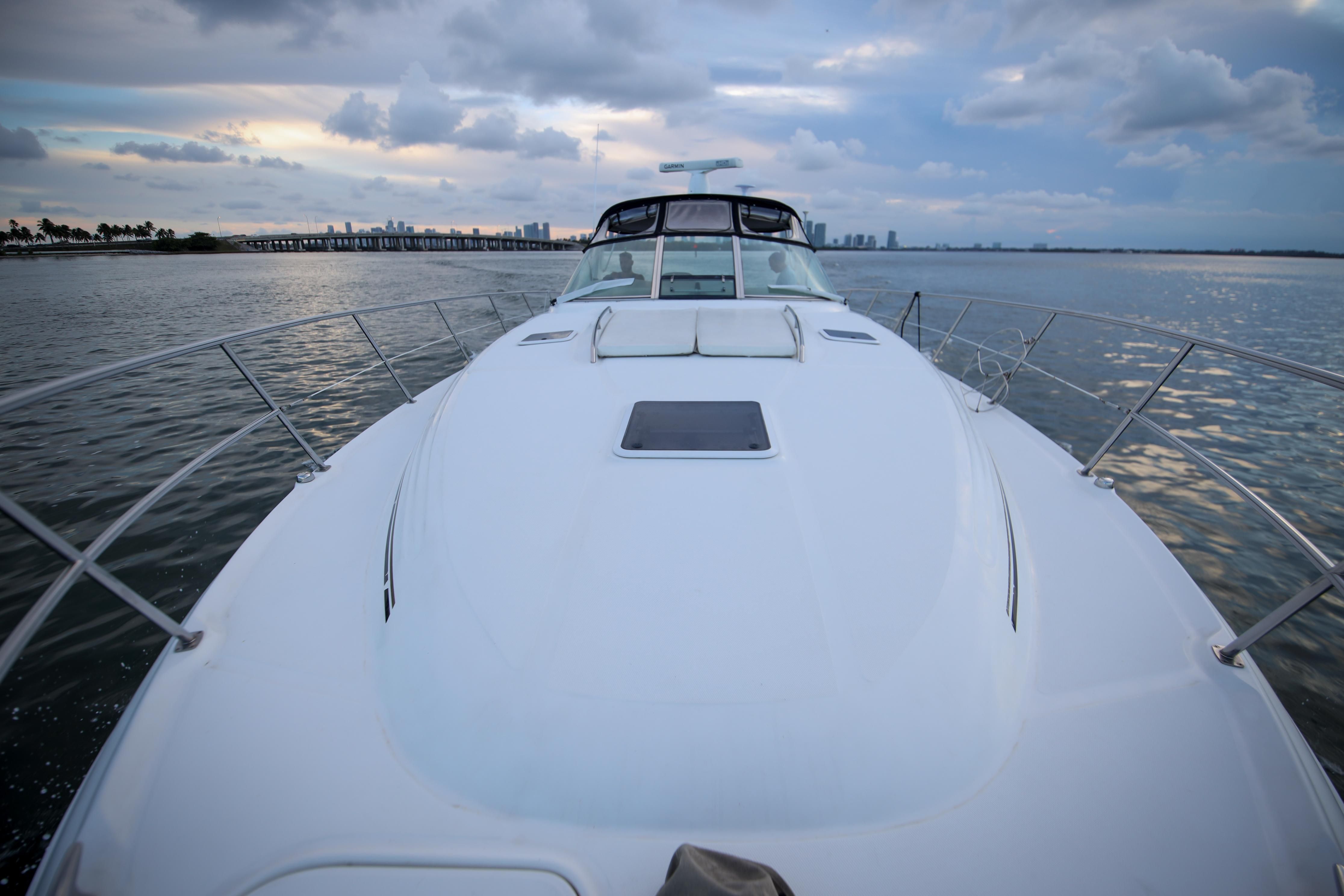2002 Sea Ray 410 Express Cruiser on calm water at sunset.