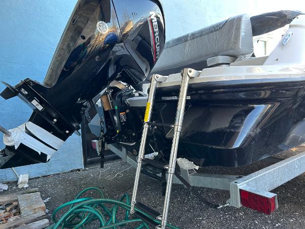 2024 Bayliner Element M19 boat with Mercury outboard motor and ladder, on a trailer.