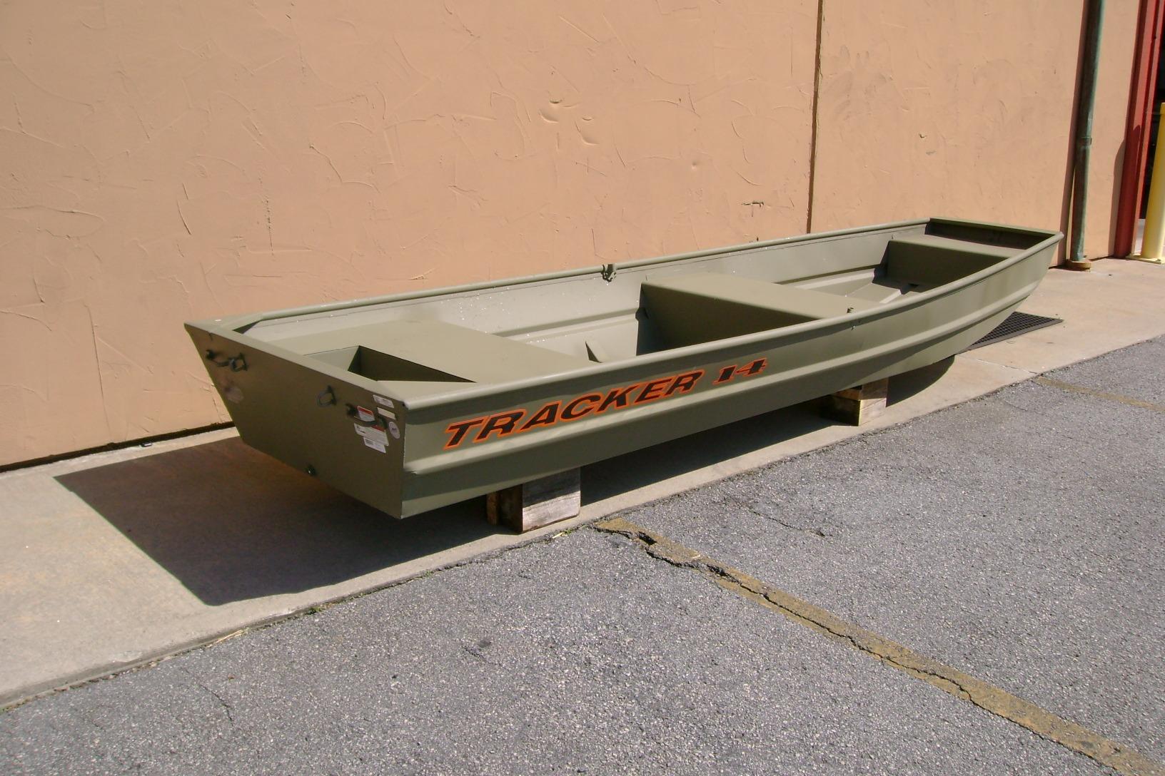 2026 Tracker Grizzly 14 Jon boat in olive green, displayed outdoors on wooden blocks.