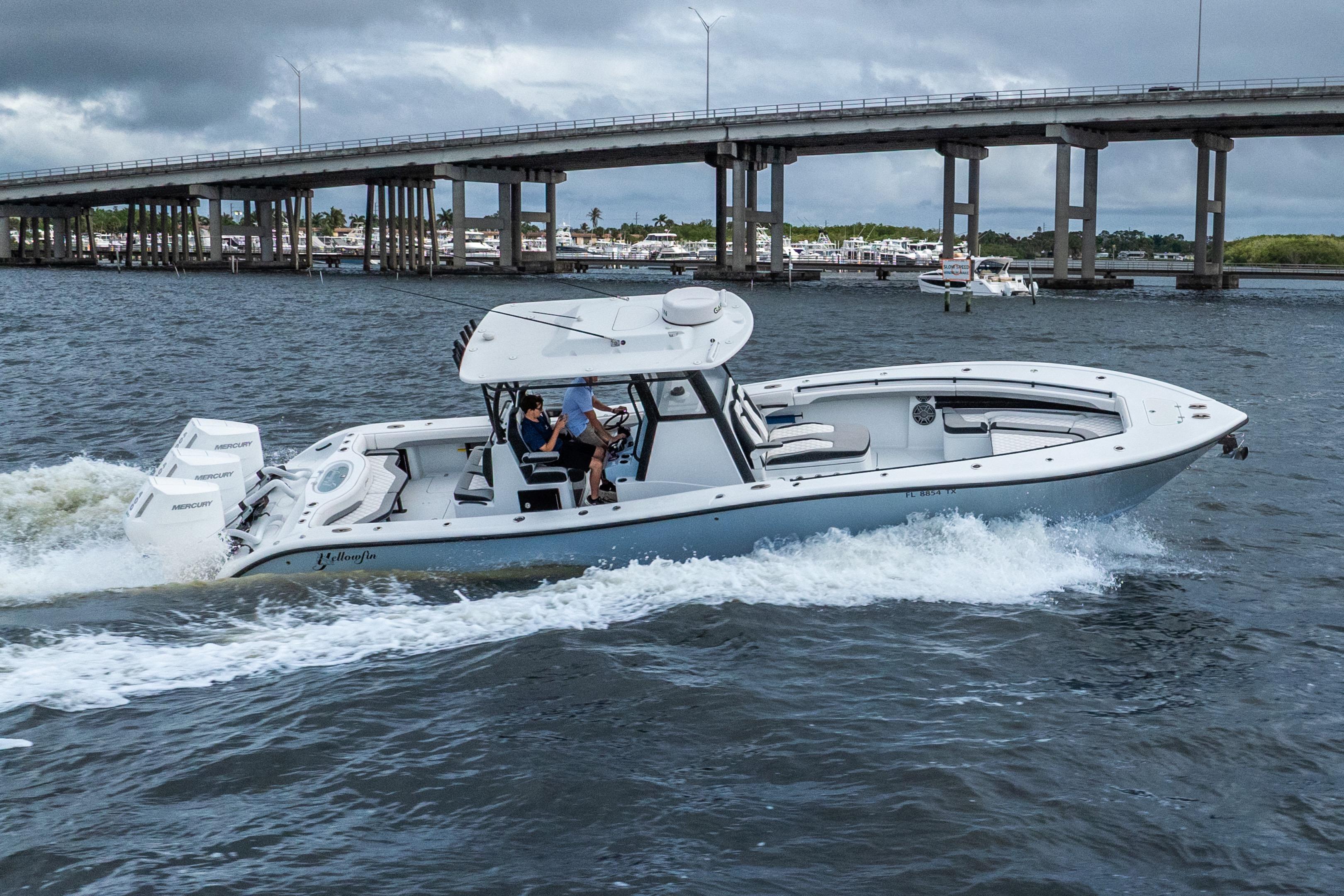 2025 Yellowfin 36 Offshore boat cruising under a bridge on a cloudy day.