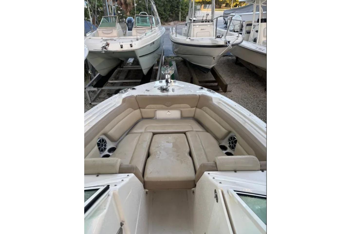 2019 Sailfish 275 DC boat with spacious seating and cup holders, docked among other boats.