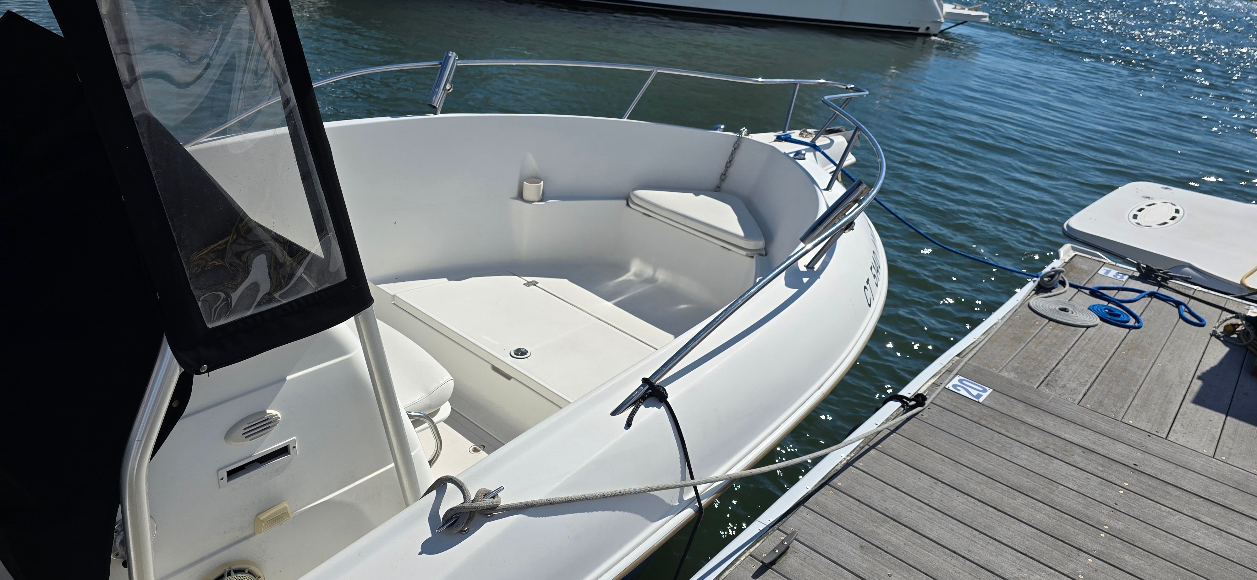 A 2003 Aquasport 205 Osprey is docked on the water.
