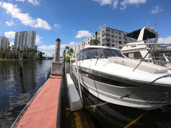 2017 Jeanneau NC 11 docked at a marina with waterfront buildings.