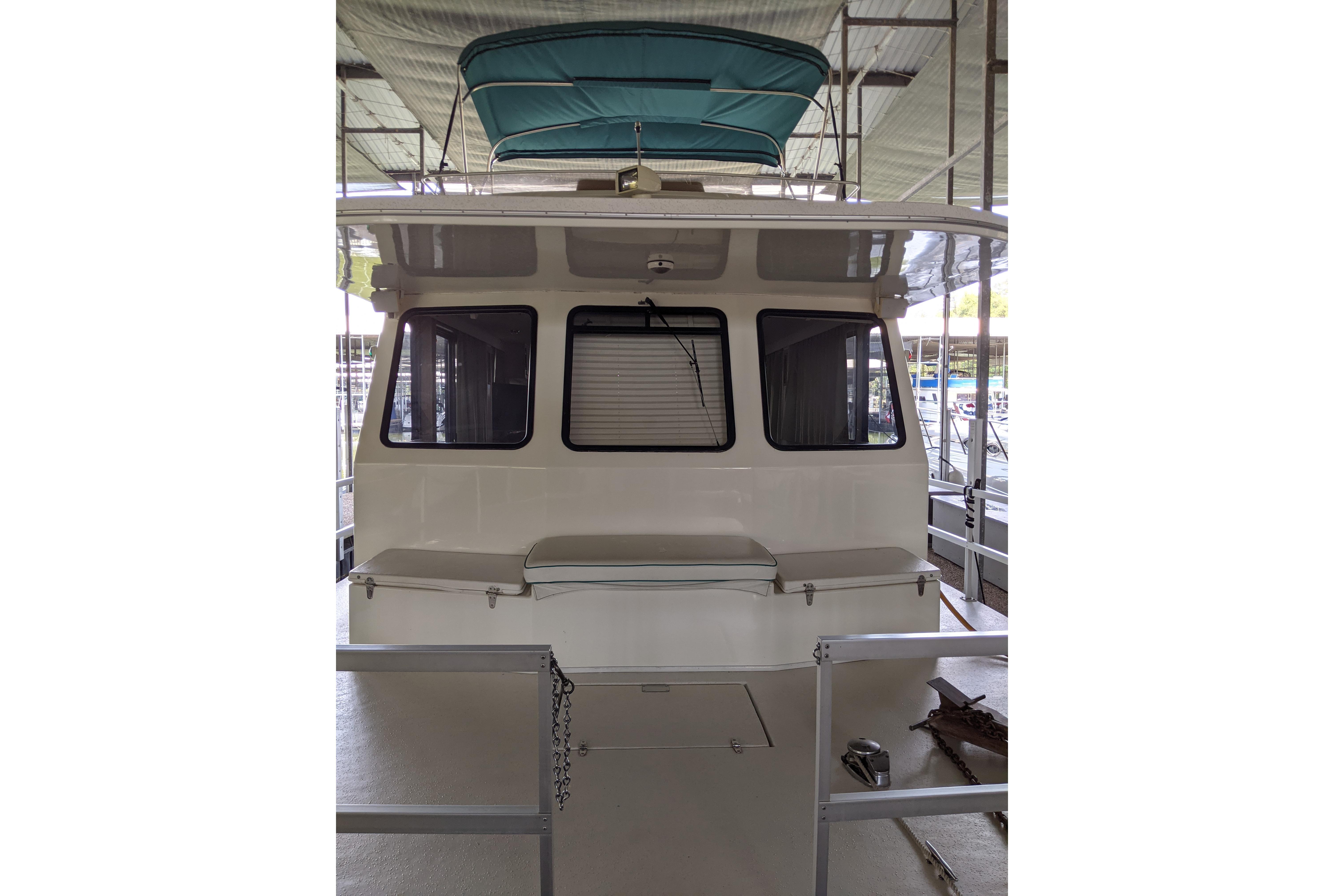 2001 Gibson 50 Cabin Yacht with teal canopy, docked in a covered marina.