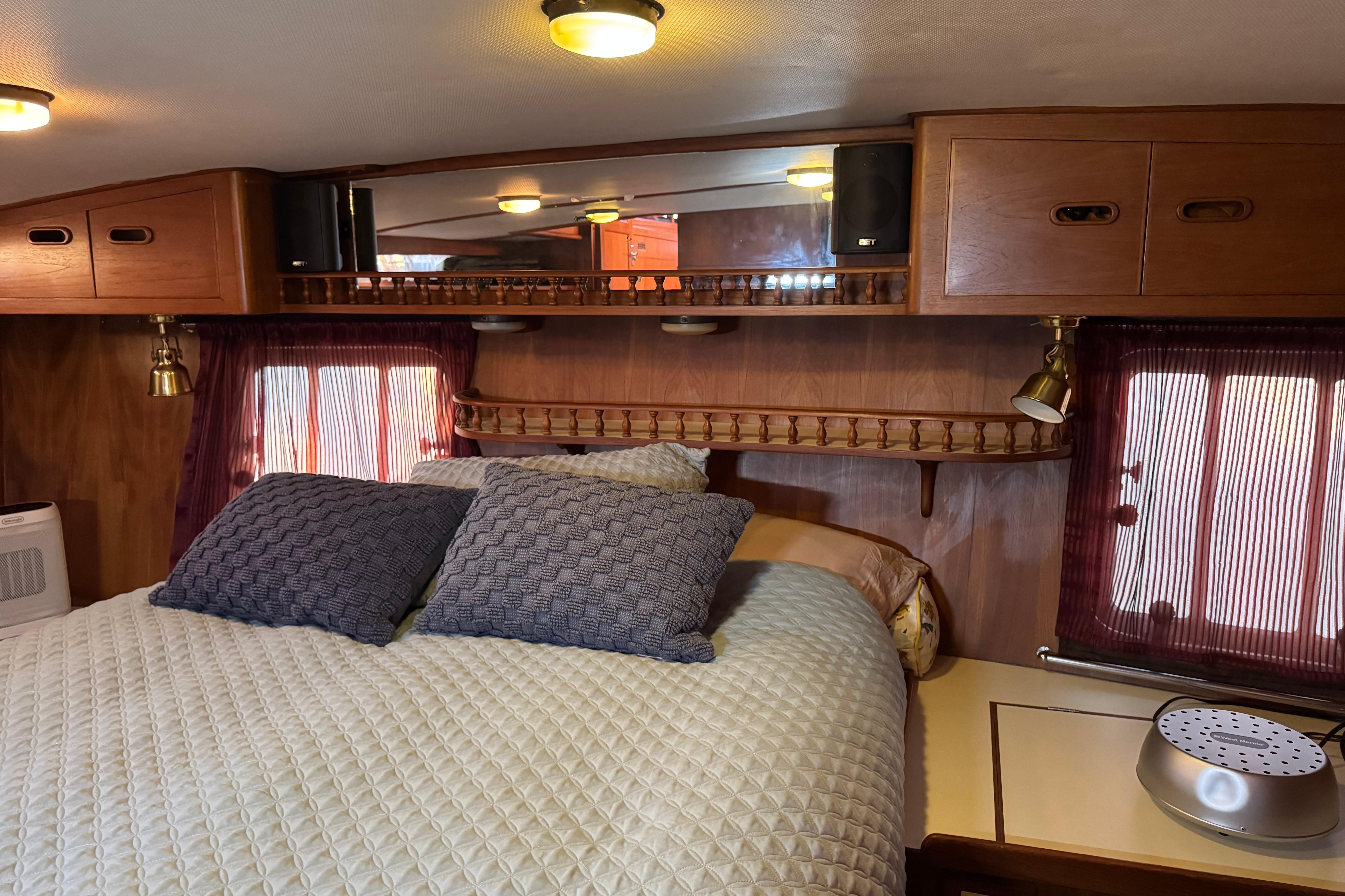Cozy bedroom interior in 1987 President 37 model with wooden cabinets and soft lighting.