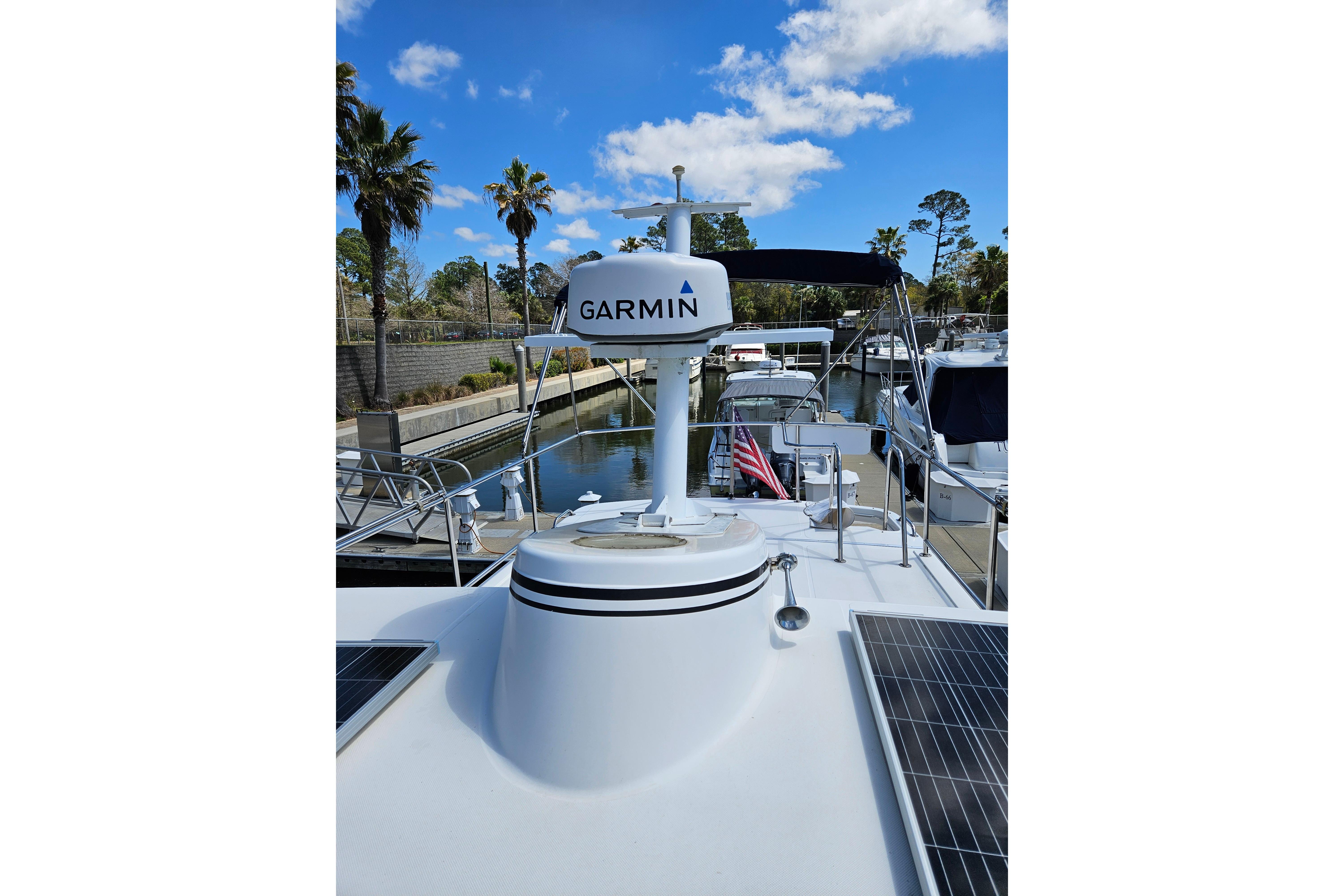 2006 American Tug AT with Garmin radar, docked near palm trees under a blue sky.