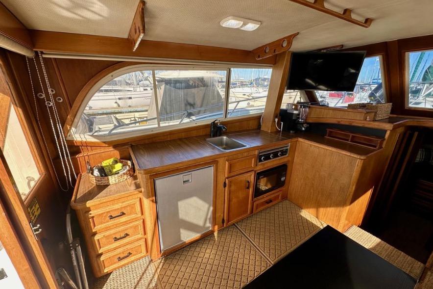 Interior of 1985 Egg Harbor 33 Sedan yacht with wooden cabinetry and kitchenette.