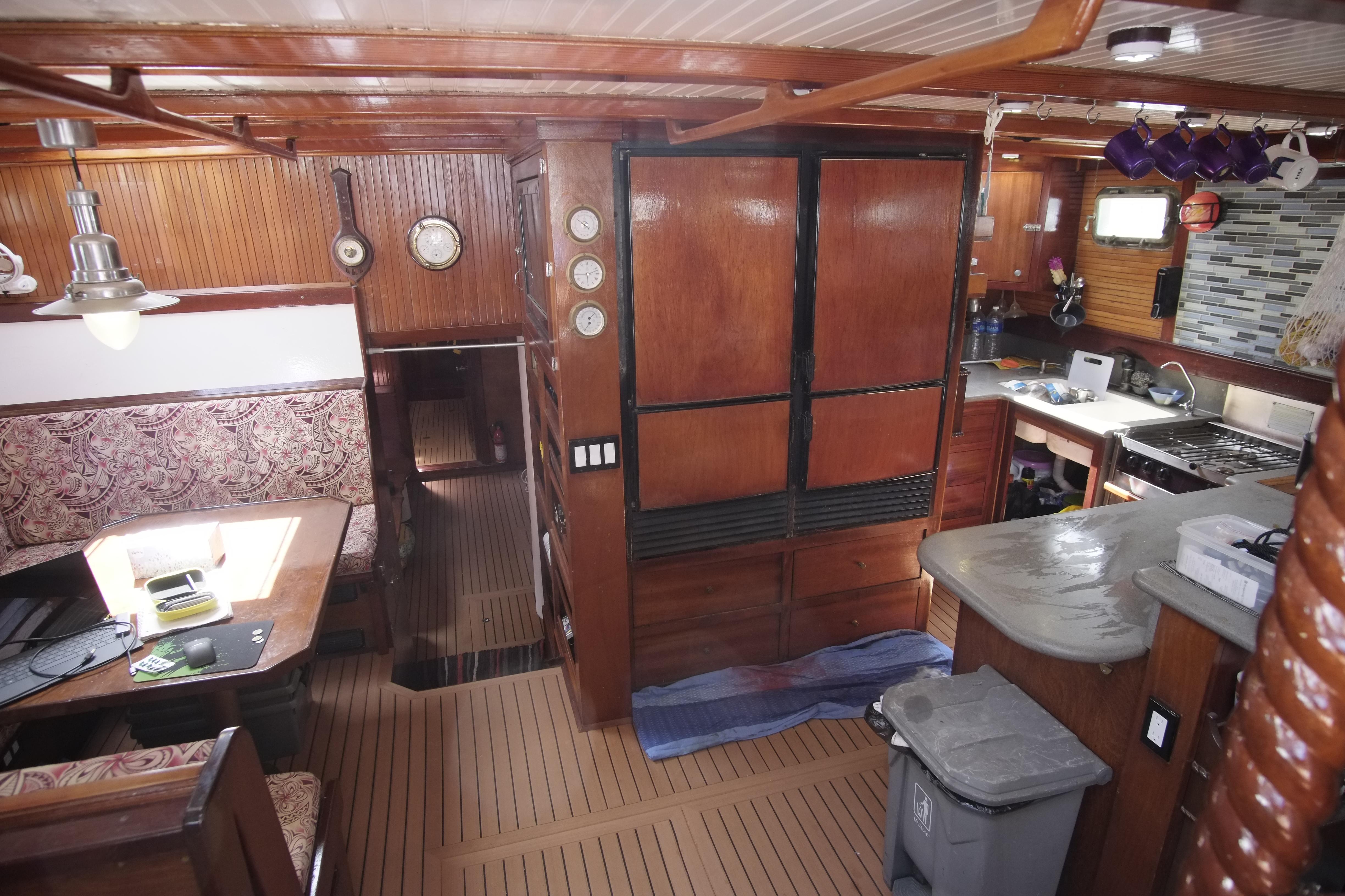 Interior of 2006 Custom Bud Macintosh schooner with wood paneling and cozy dining area.