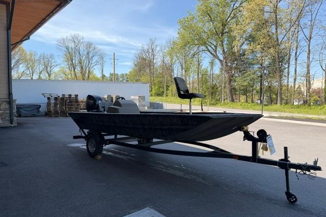 2026 Tracker Grizzly 1754 SC boat on trailer, parked outdoors, surrounded by trees.