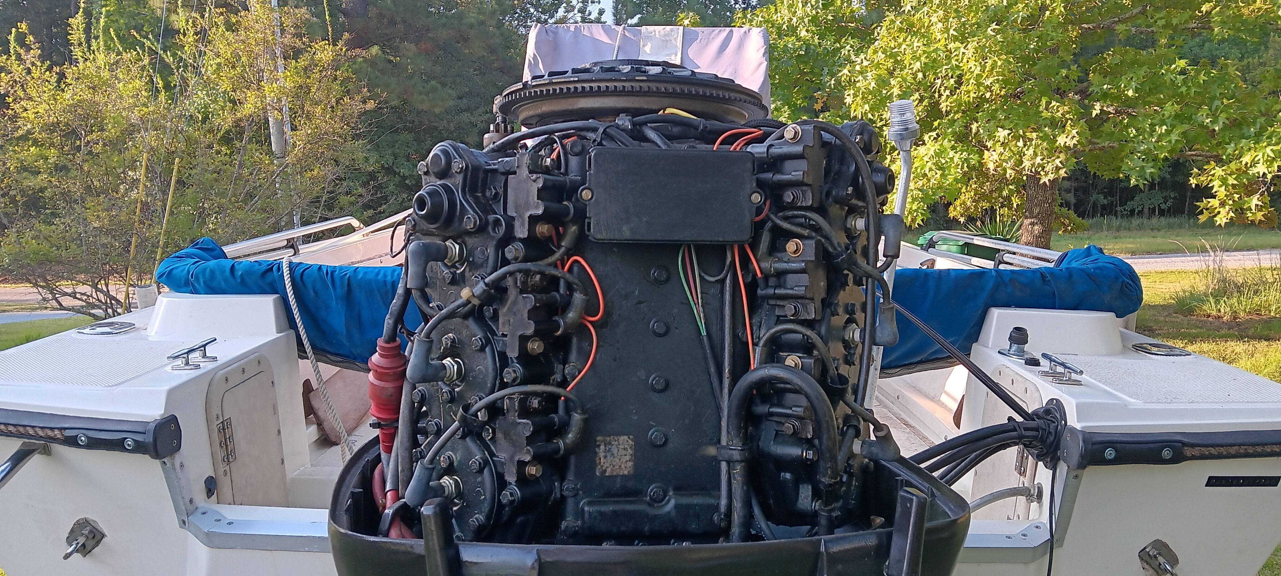 A 1990 Hydra-Sports Vector with an exposed engine, surrounded by trees and grass.