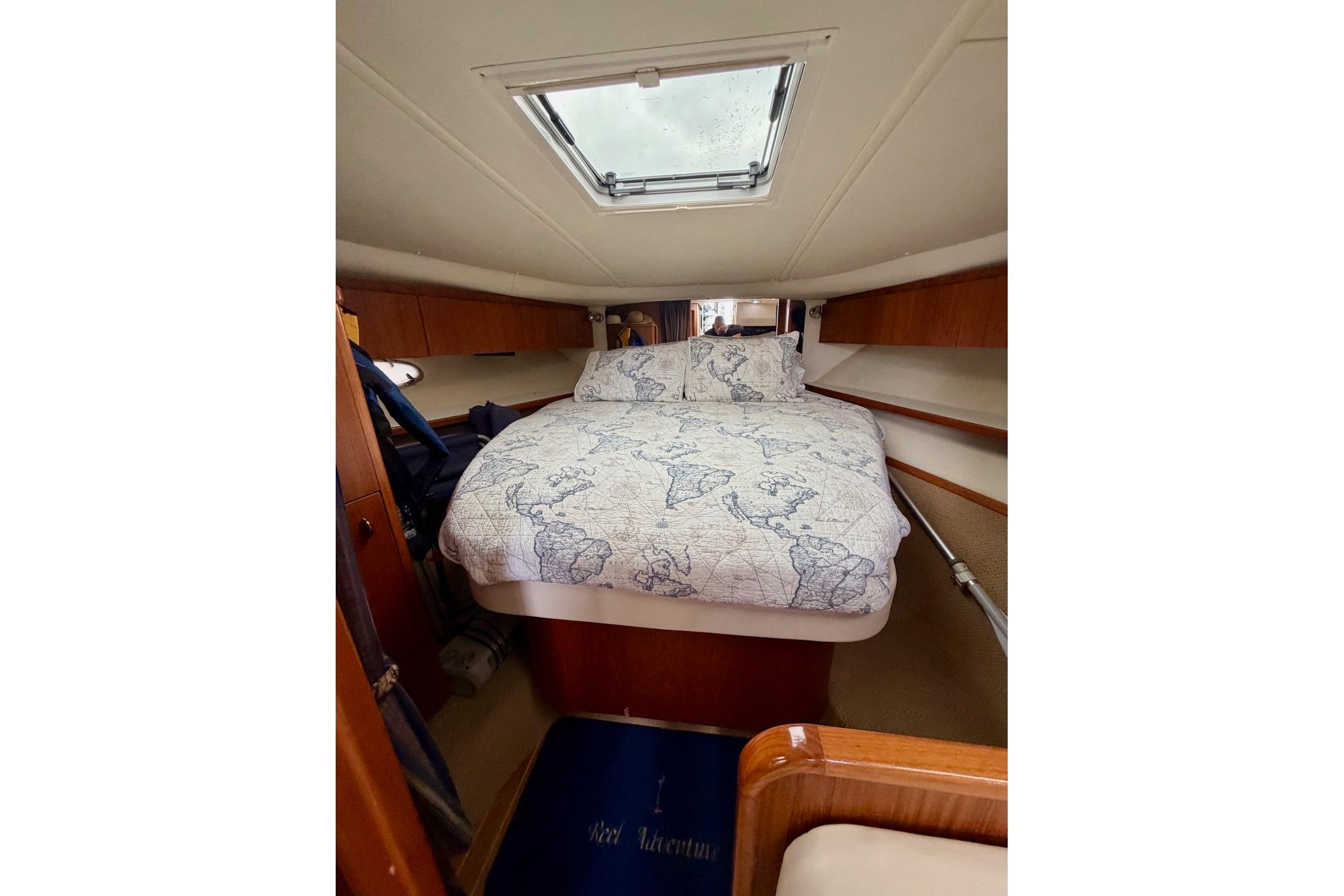 2003 Tiara Yachts 3500 Open cabin with map-themed bedding and overhead skylight.