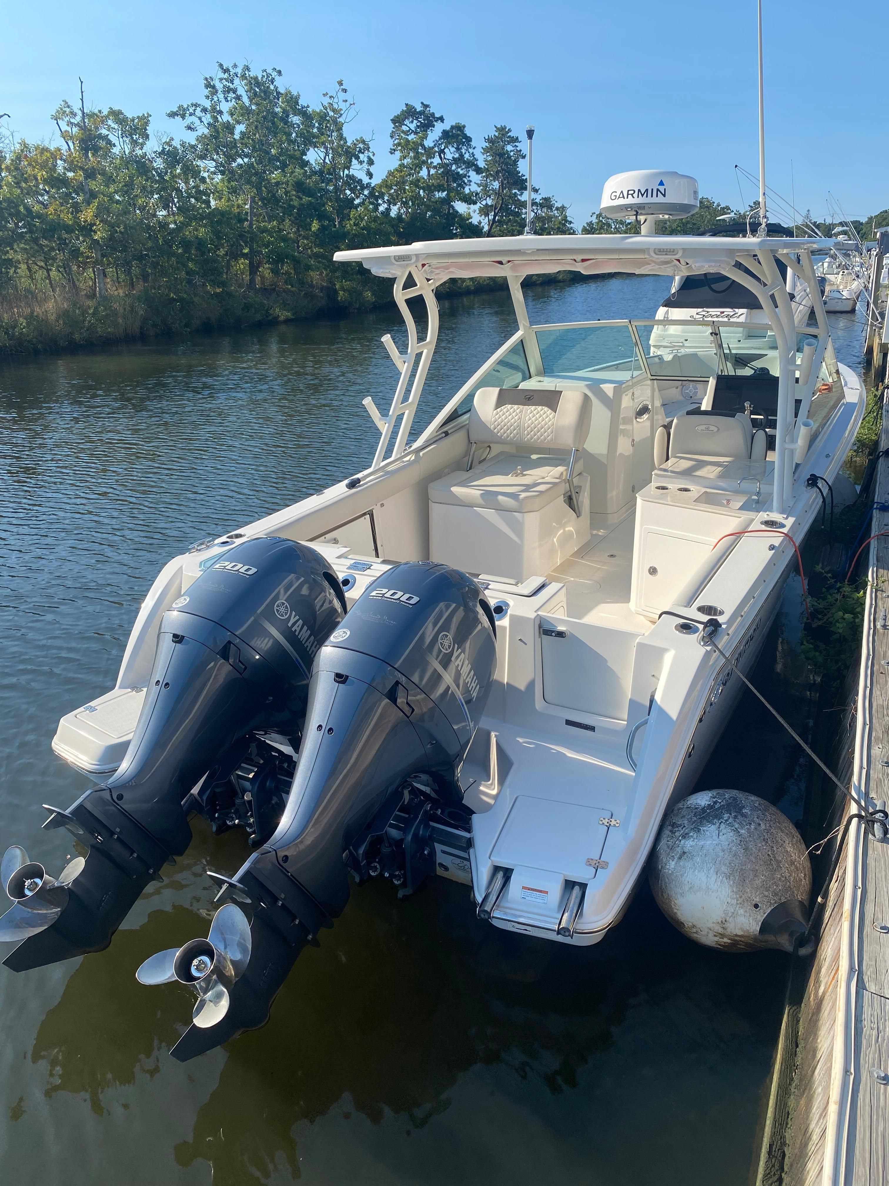 Sailfish 276 DC 2022 boat with twin Yamaha engines at dock.