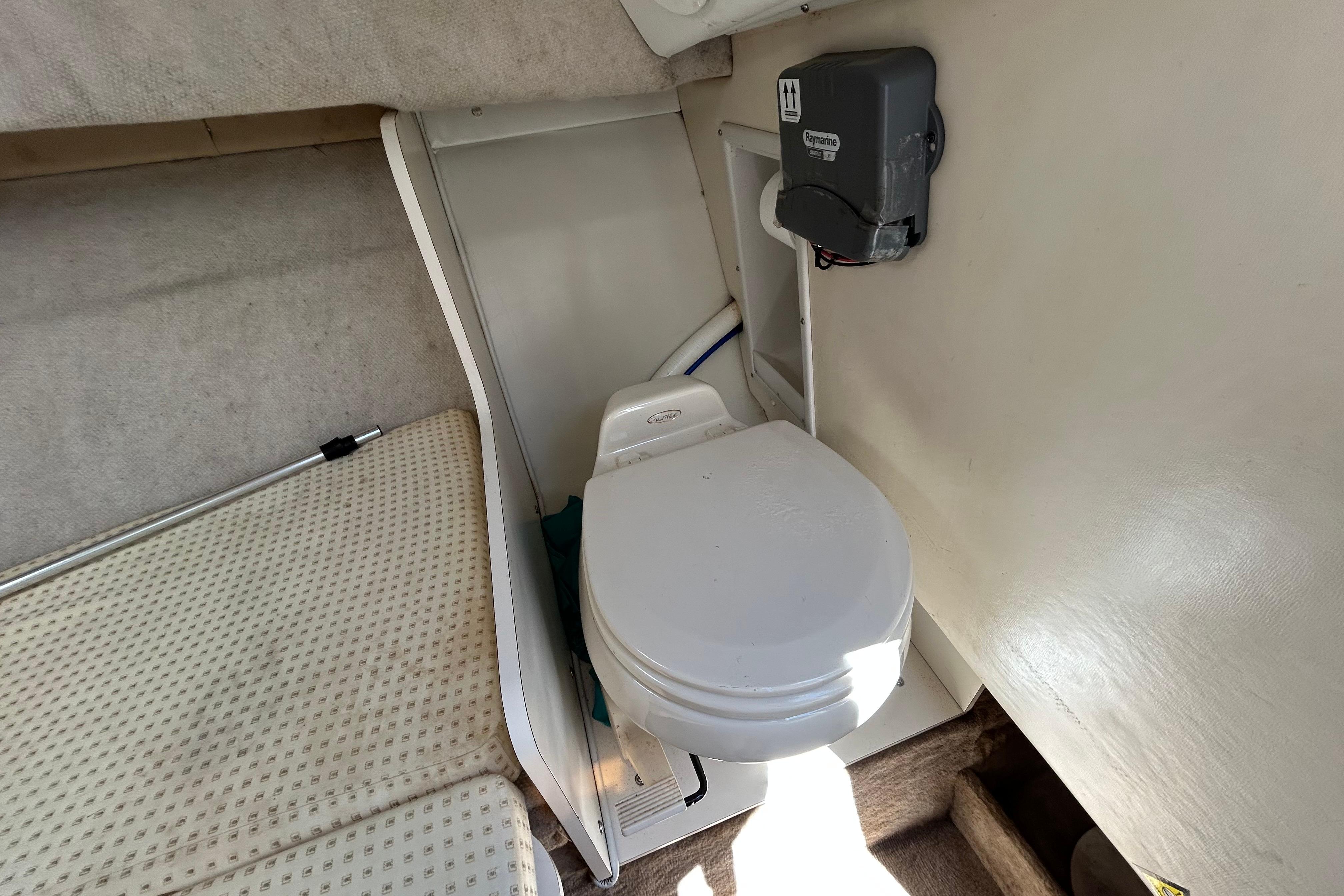 Interior of 2003 Wellcraft 220 Coastal boat featuring a compact marine toilet.