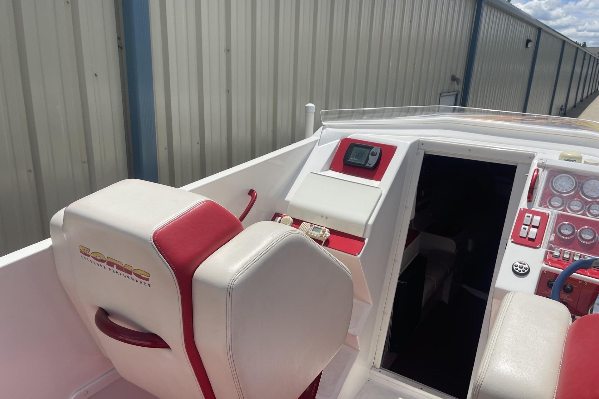 2006 Sonic 386 boat cockpit with red and white seating and control panel.