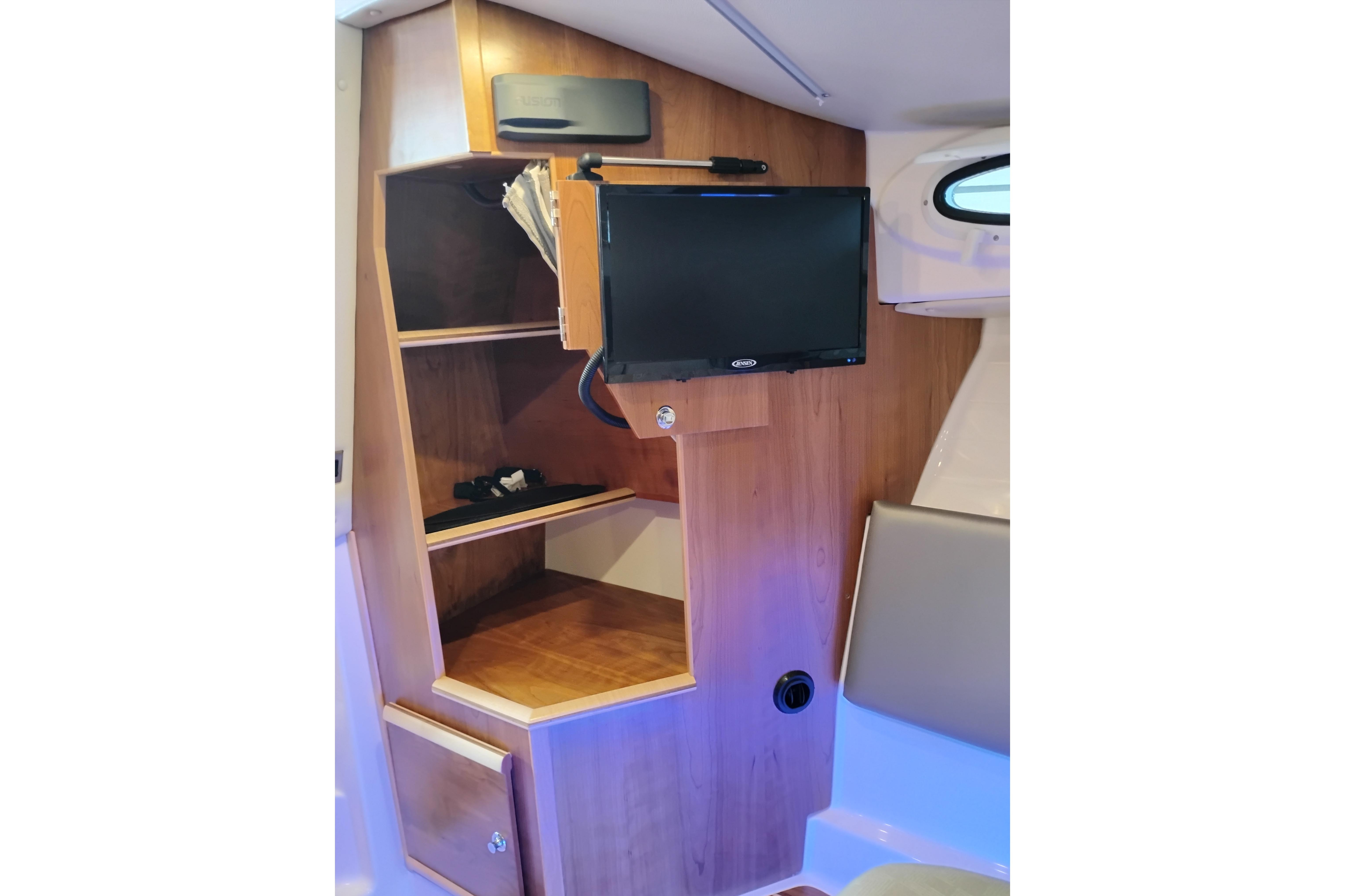 Interior of 2022 Cutwater C-32 Coupe featuring wooden cabinetry and mounted TV.