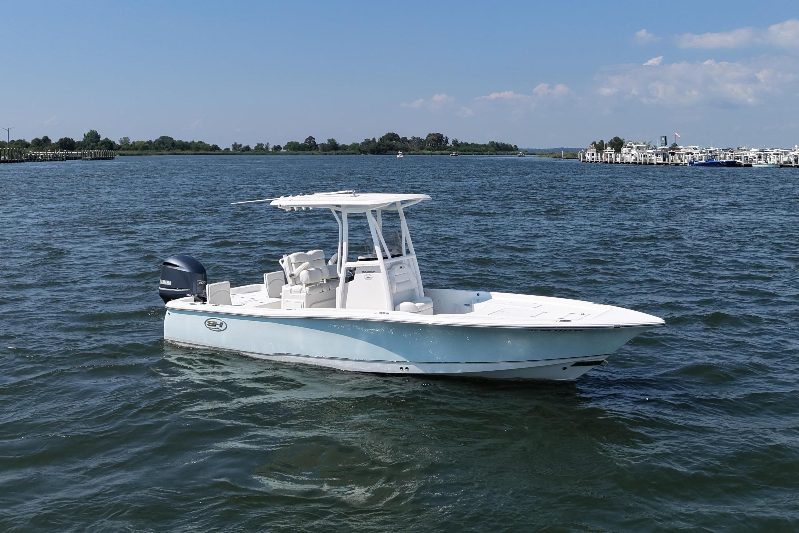 A 2017 Sea Hunt BX 25 BR boat on the water with a blue sky in the background.