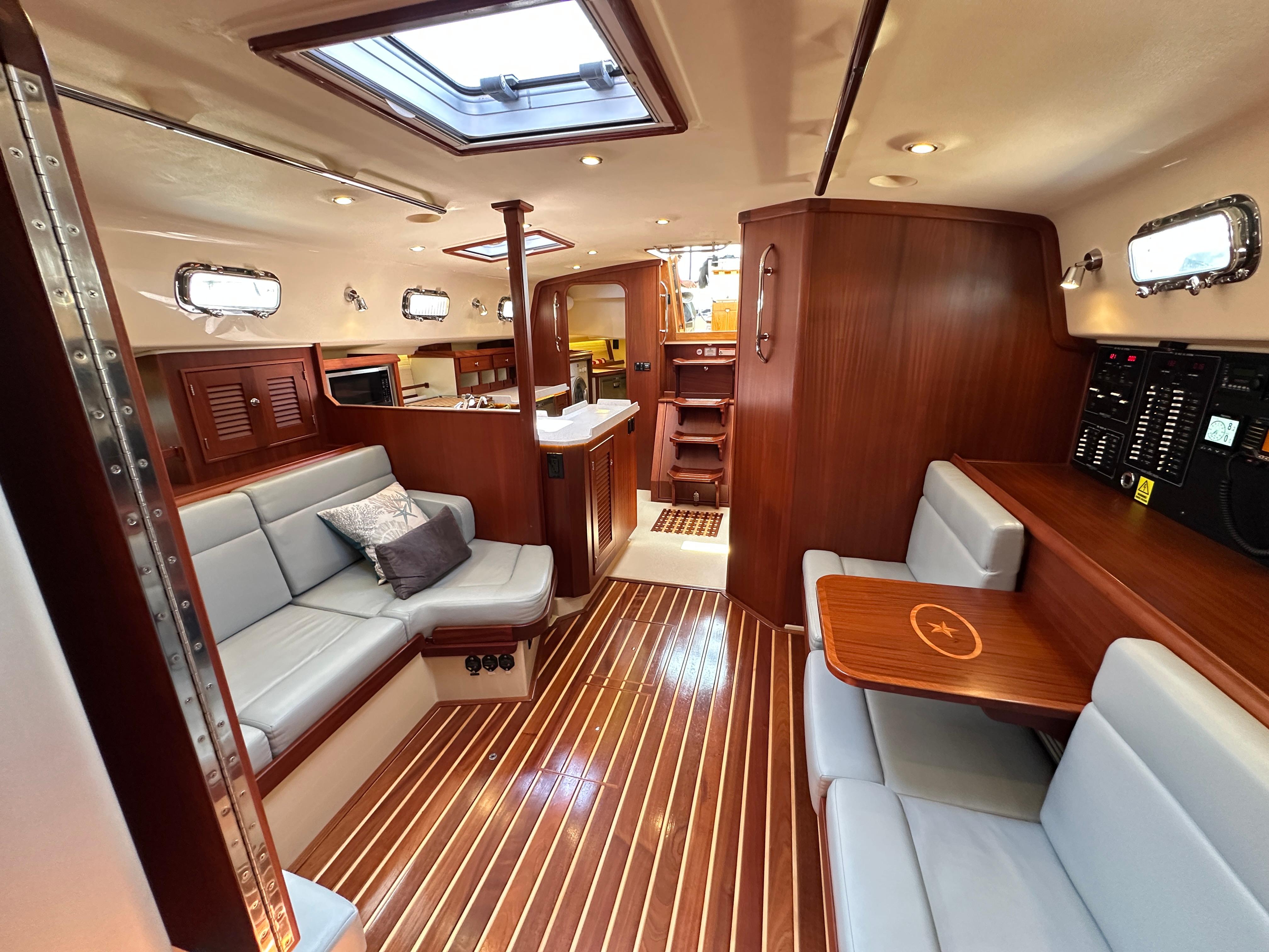Luxurious interior of 2021 Island Packet 439 yacht with elegant wood finishes and comfortable seating.