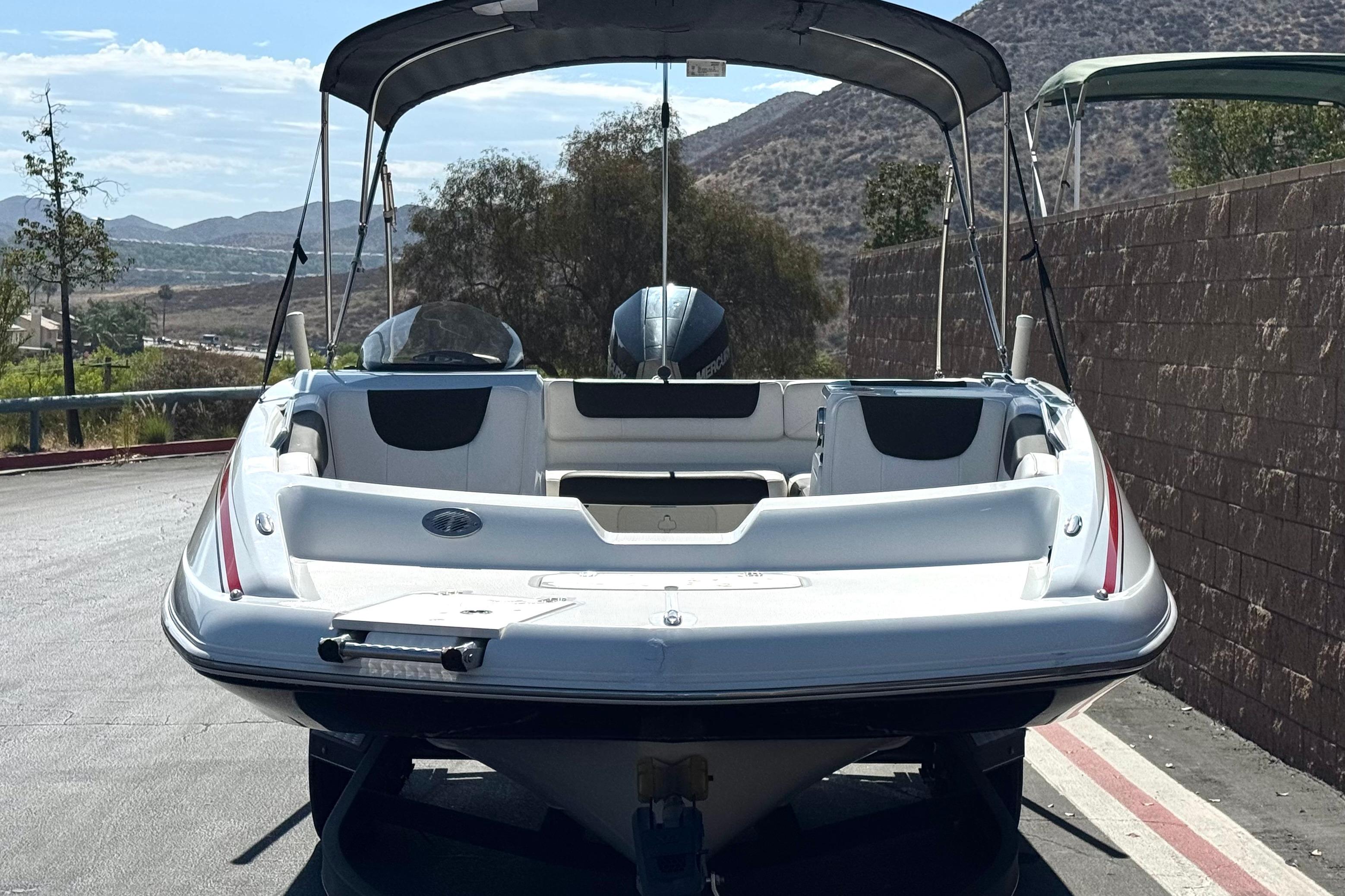 2019 Tahoe 2150 boat with canopy, parked on a scenic road.