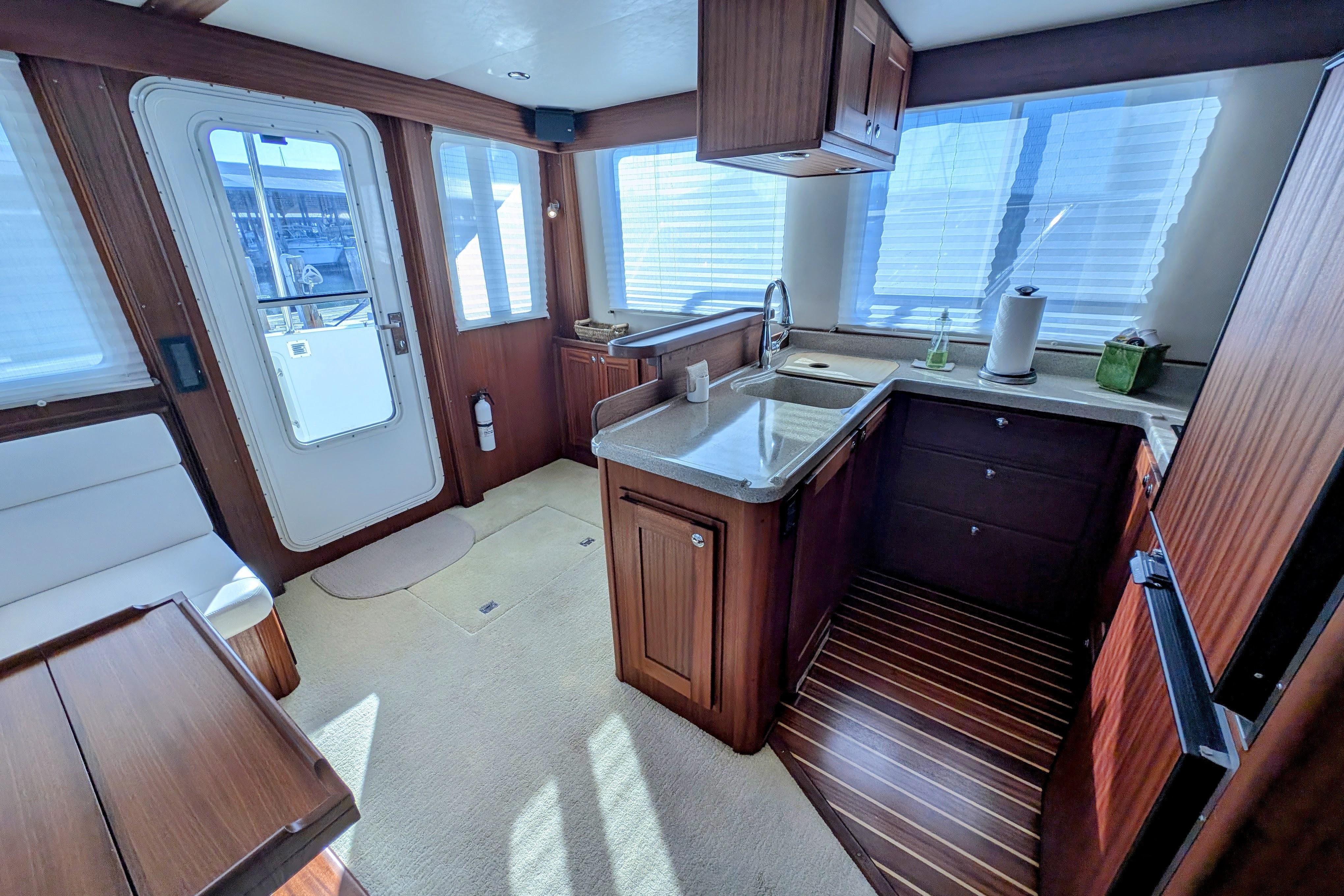 Luxurious interior of 2015 American Tug 435 with modern kitchen and elegant wood finishes.