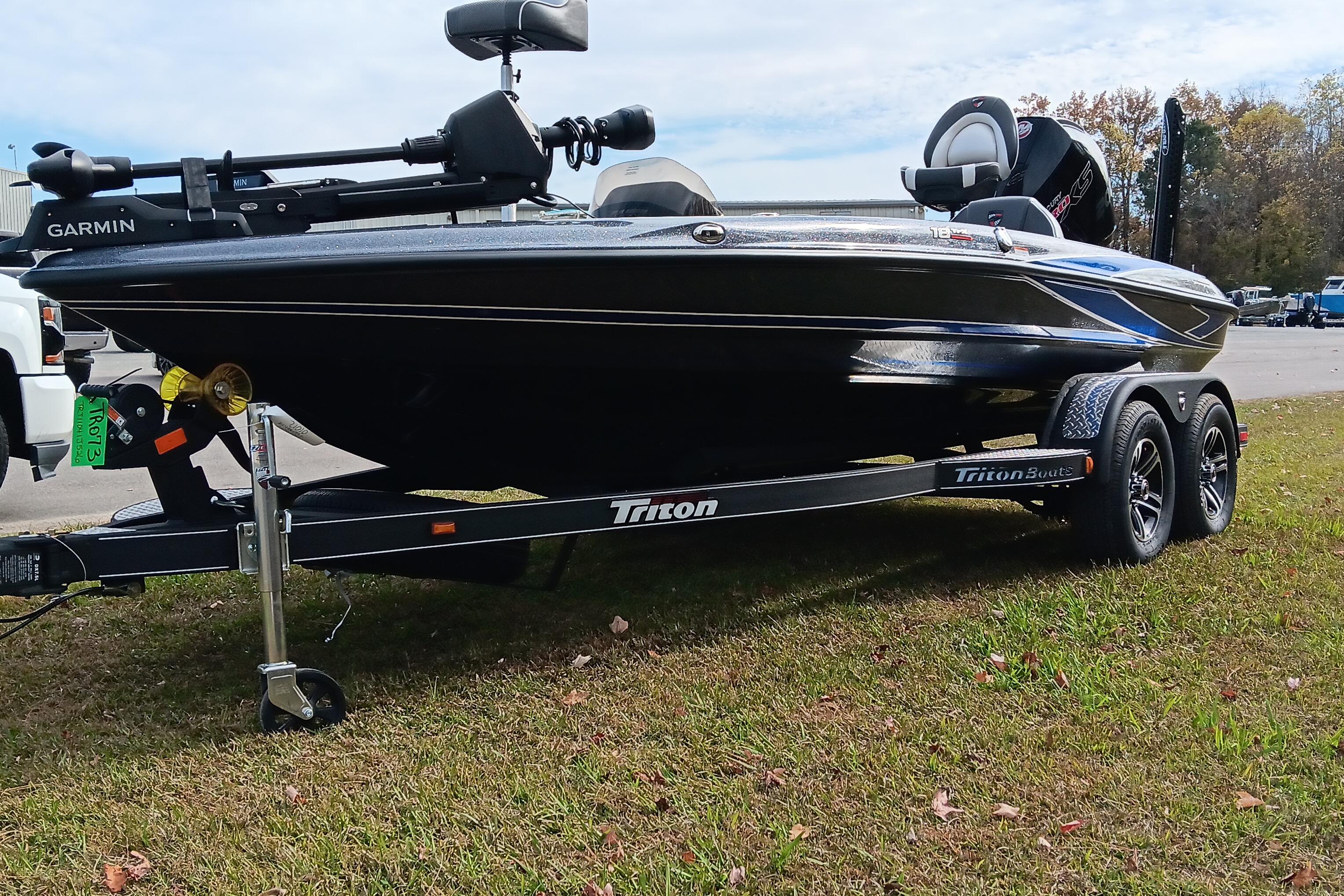 2026 Triton 18 TrX boat on trailer, parked on grass, featuring Garmin equipment.