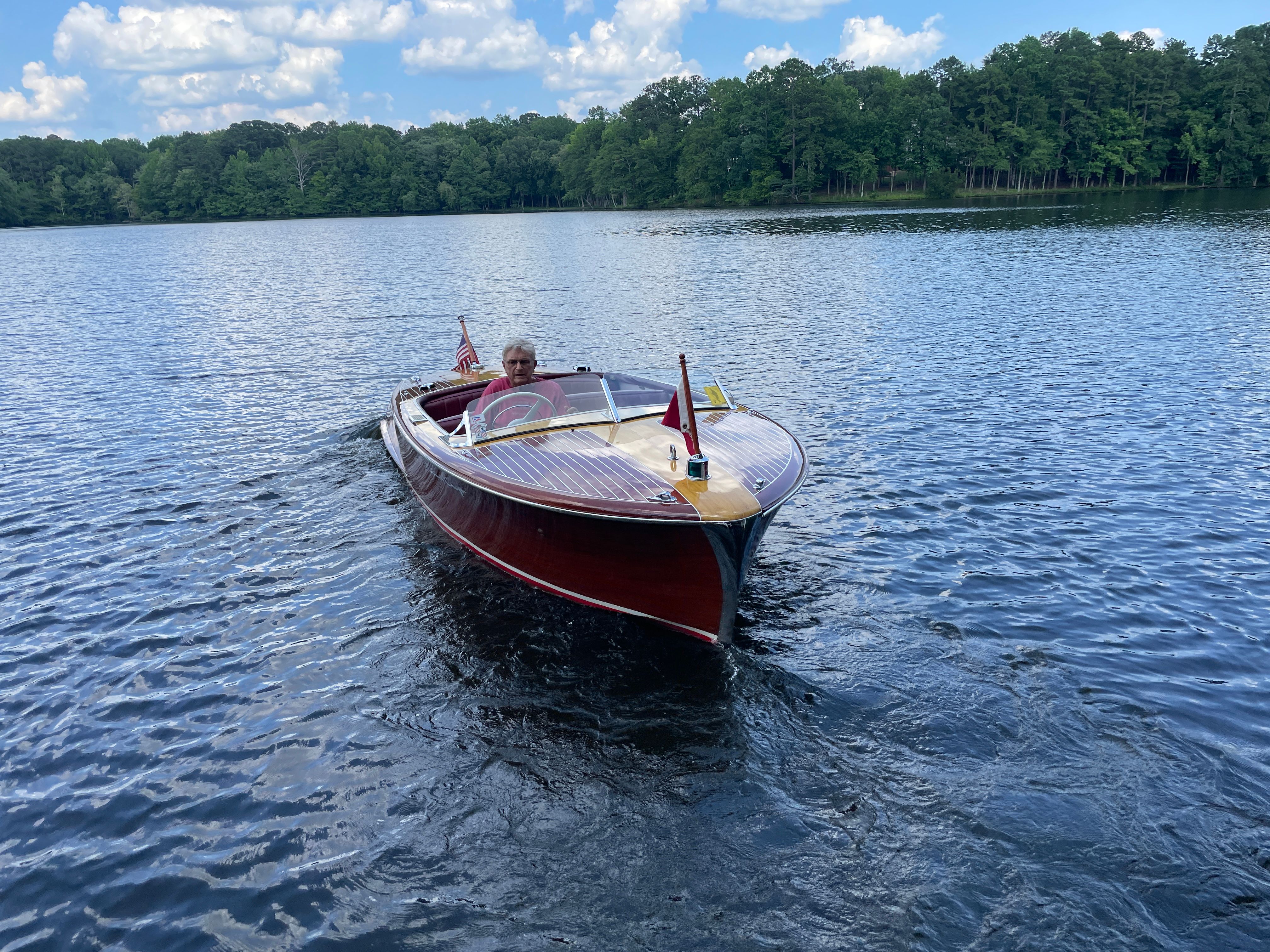 1954 Chris-Craft Riviera on a serene lake.