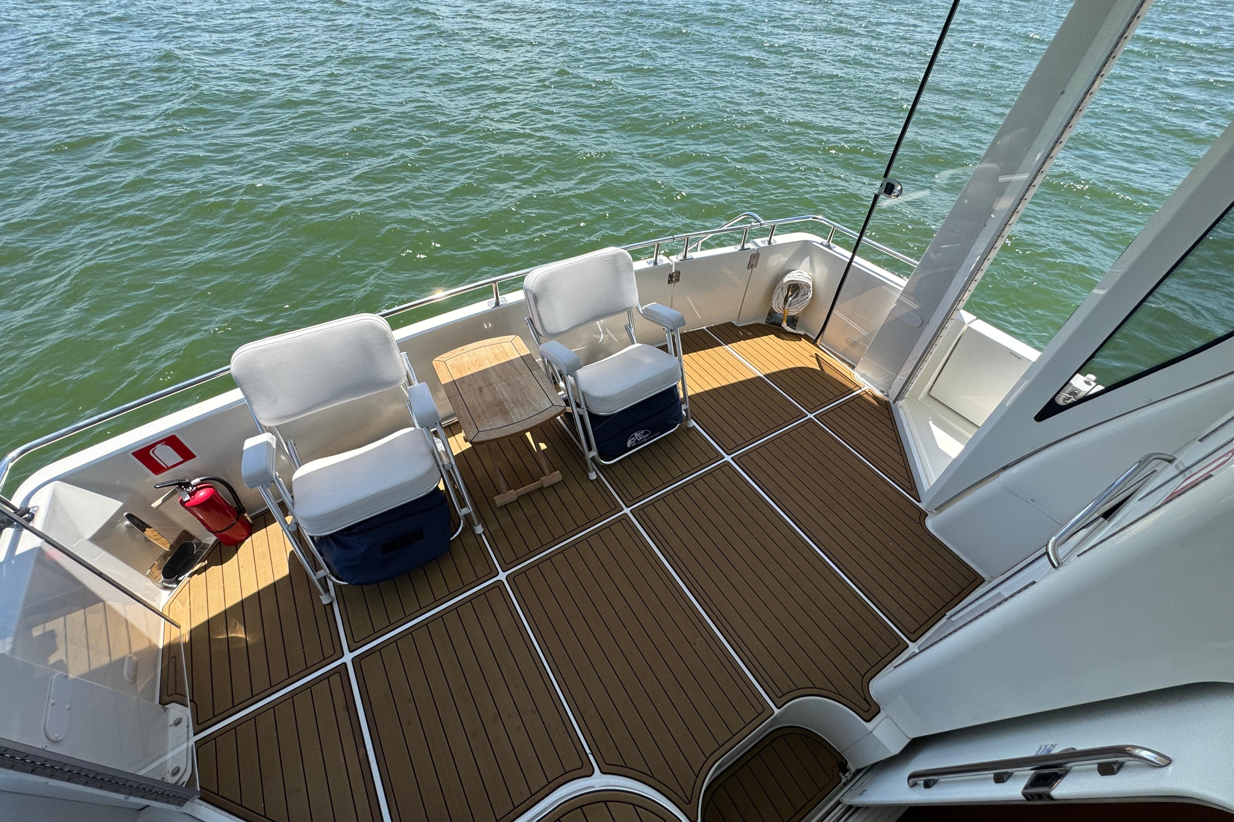 2002 Carver 396 Motor Yacht deck with chairs, table, and ocean view.