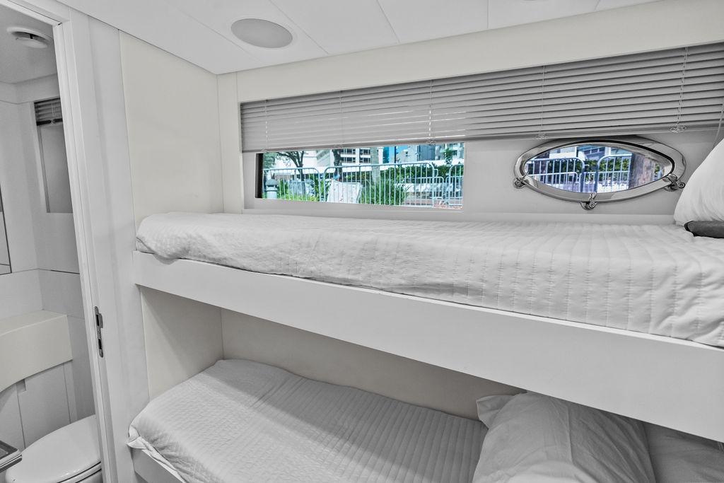 Bunk beds in a 2019 Pershing 9X yacht cabin with window view.