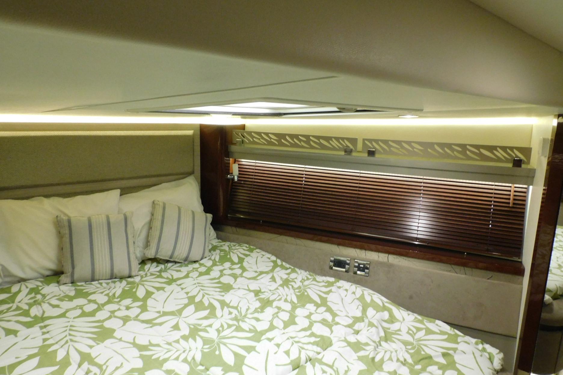 Luxurious 2019 Sea Ray L550 yacht bedroom with floral bedding and elegant lighting.