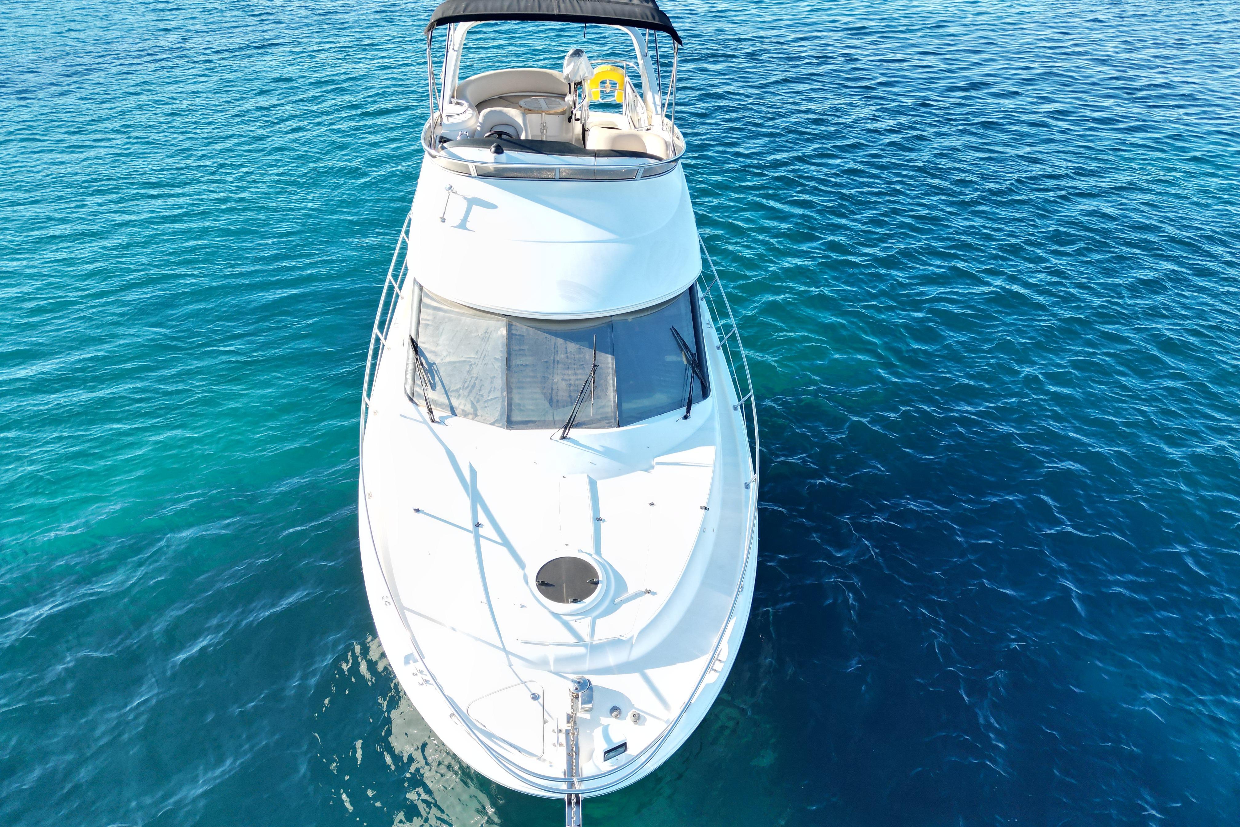 2008 Meridian 341 Sedan yacht on clear blue water, aerial view.