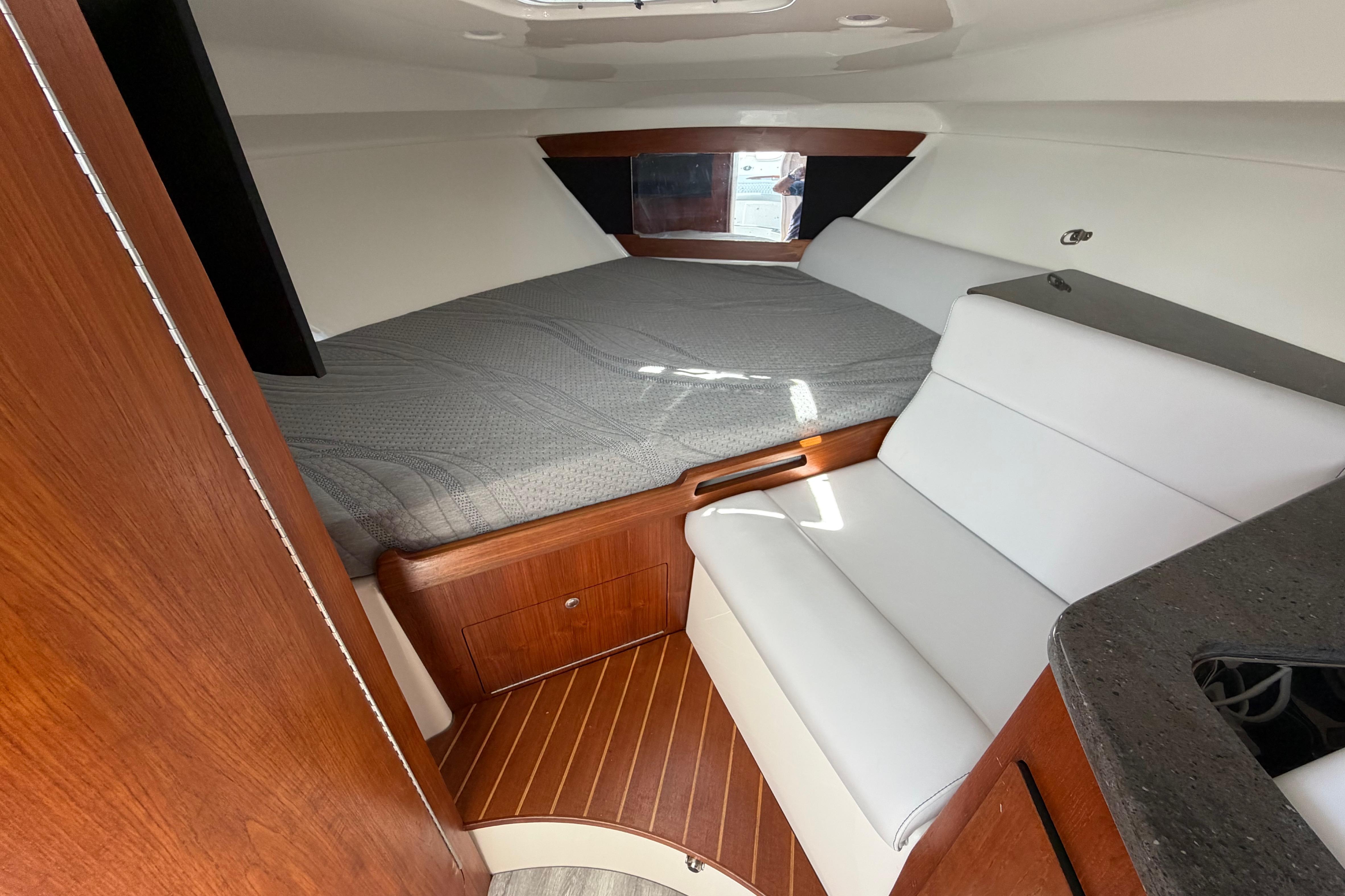 2009 Everglades 350LX cabin interior with bed, seating, and wood accents.
