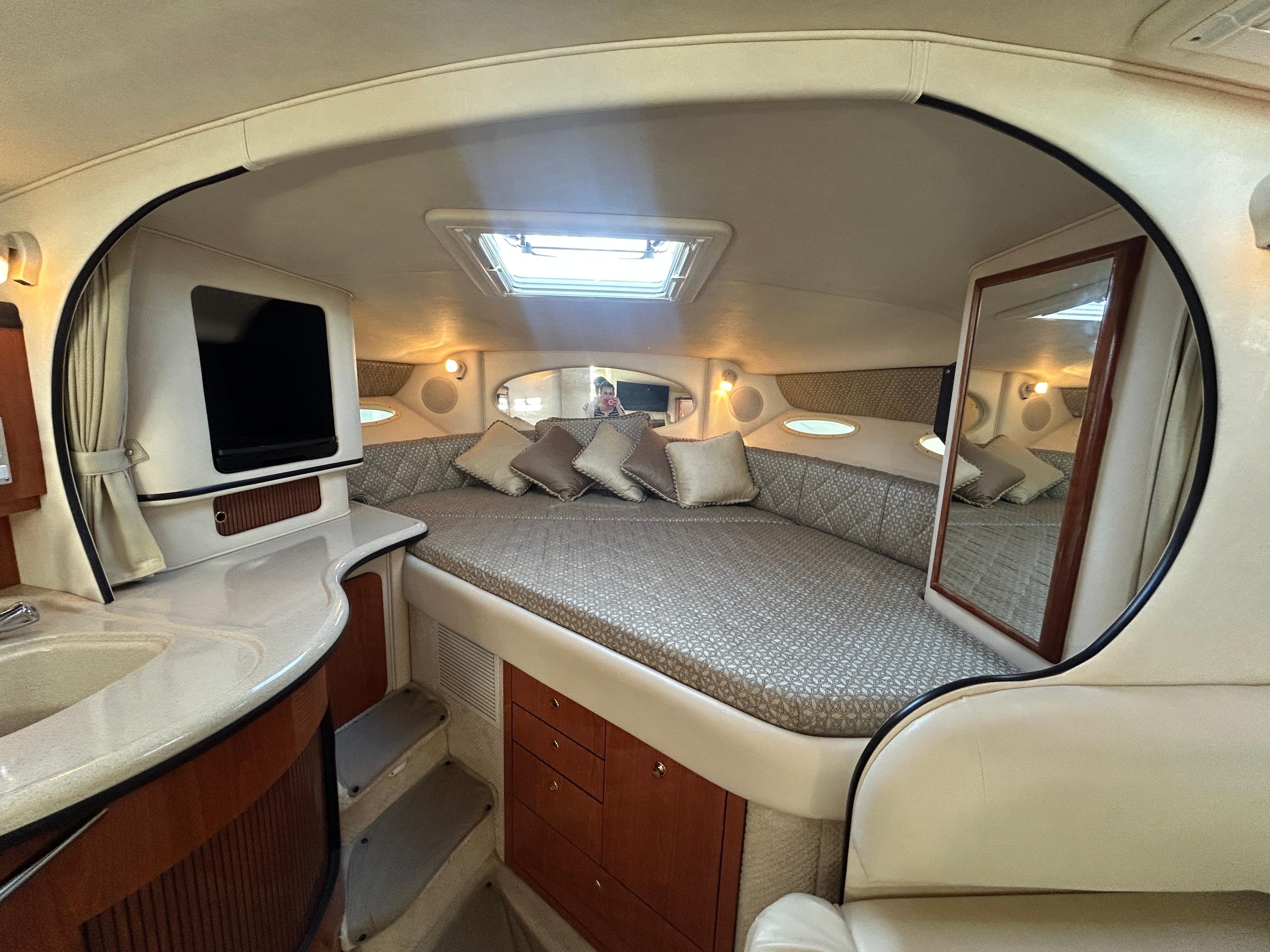 Luxurious interior of 2001 Sea Ray 310 Sundancer yacht with cozy bed and modern amenities.