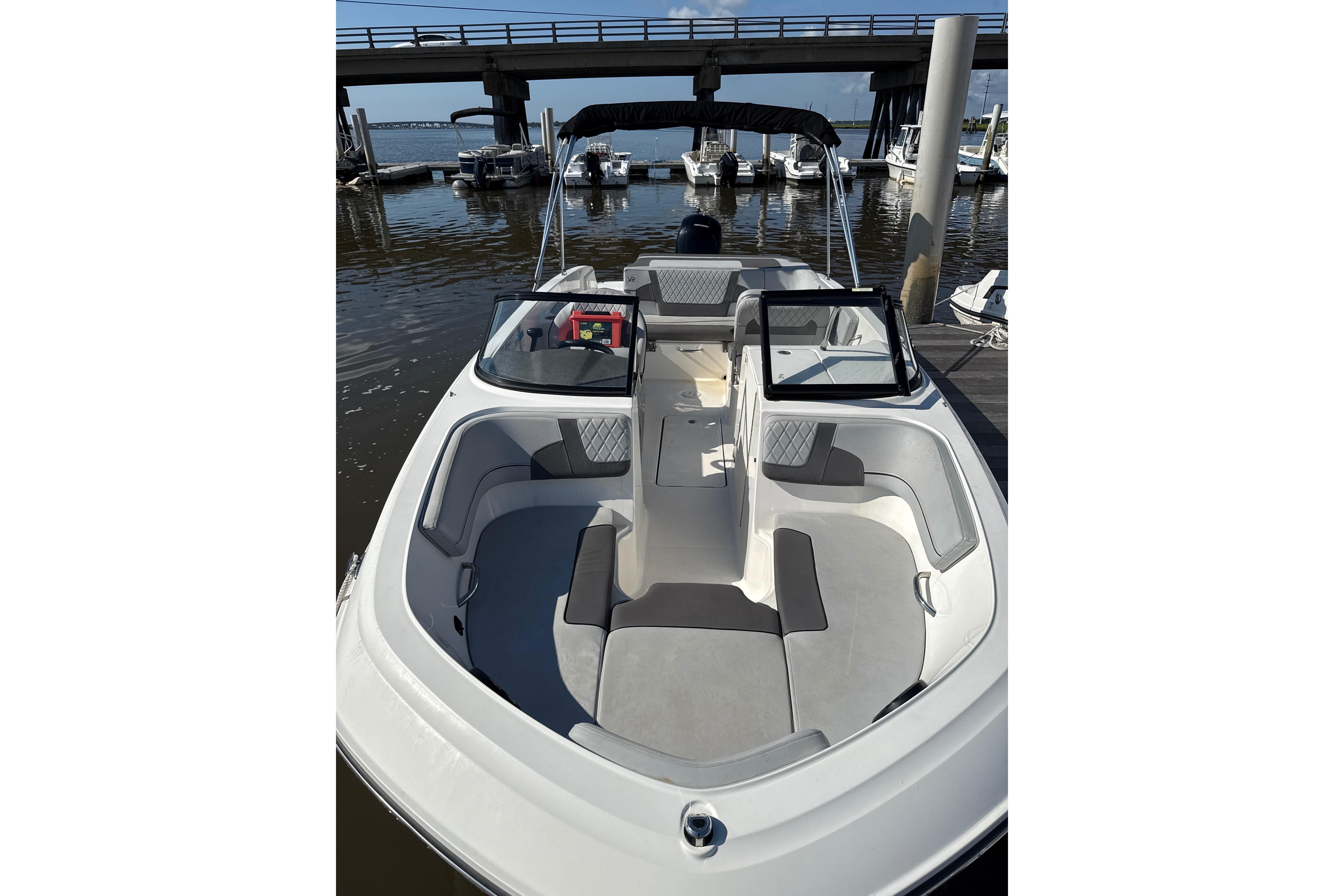 2023 Bayliner VR6 Bowrider OB at dock, featuring spacious seating and sleek design.