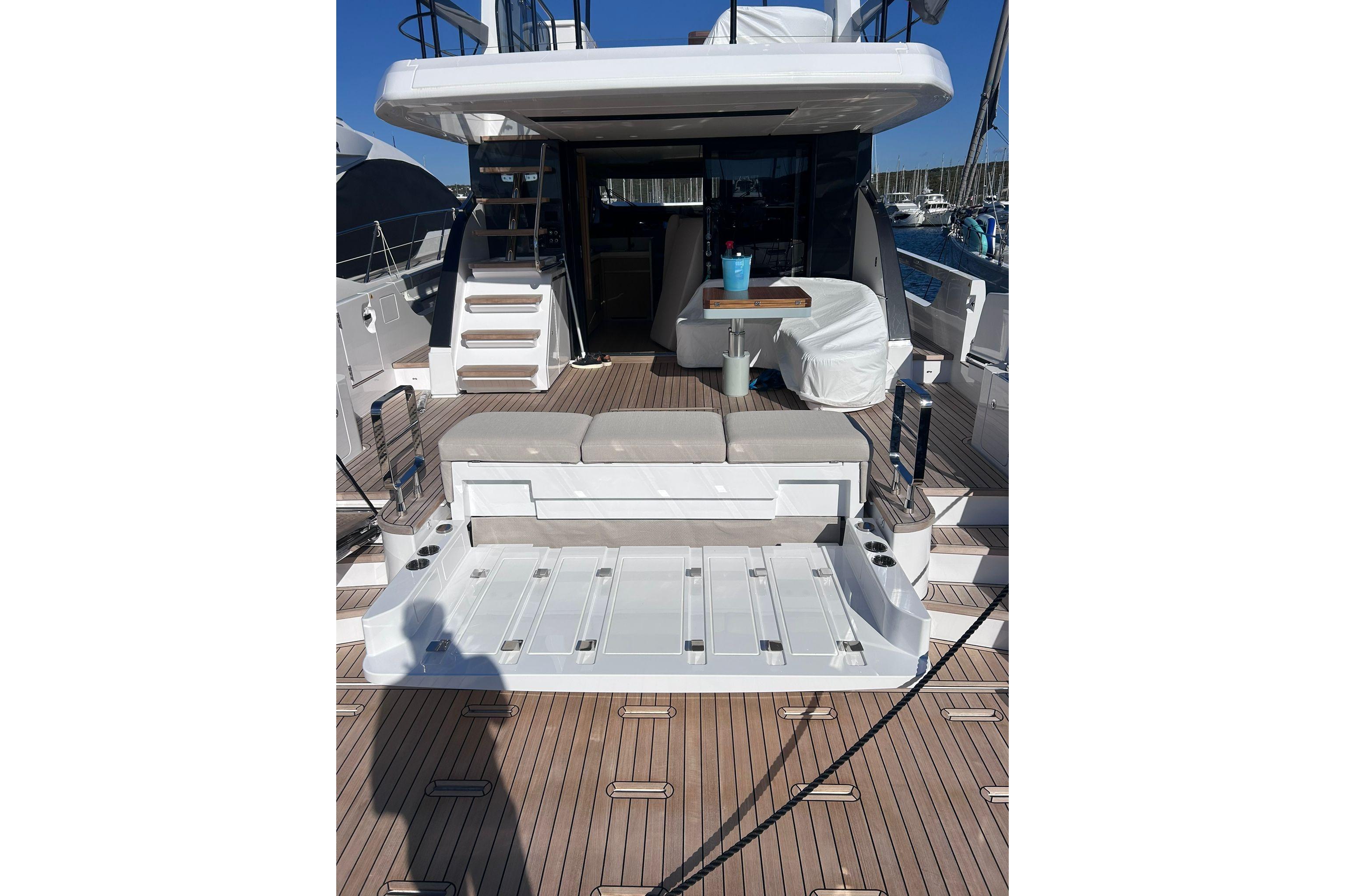 2025 Azimut Fly 62 yacht deck with seating and table, showcasing luxury design.