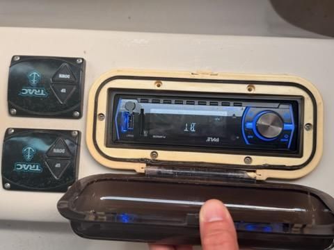 Close-up of a boat radio panel with controls and protective cover.