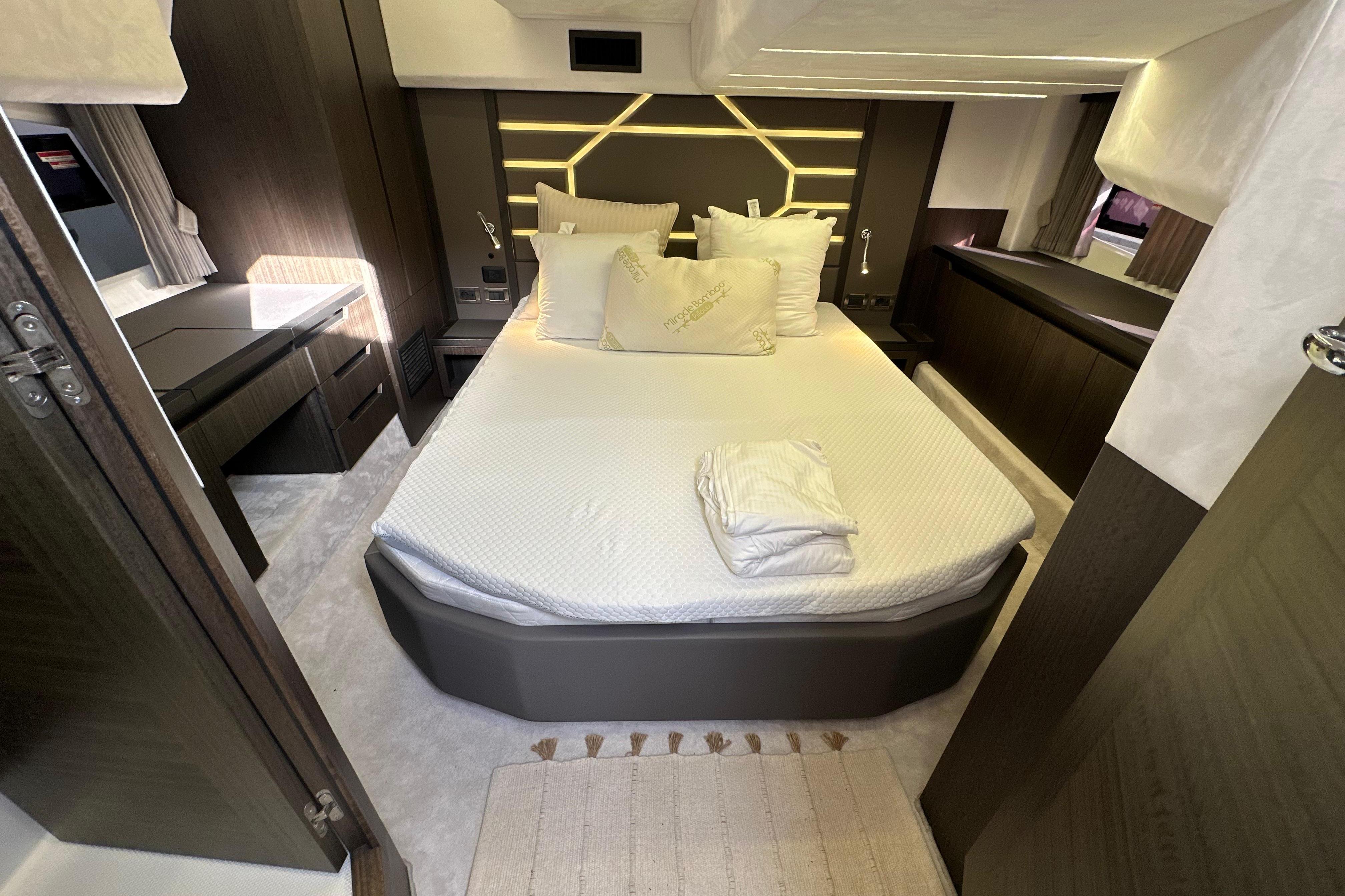 Luxurious bedroom interior of 2018 Galeon 425 HTS yacht with modern design and cozy bedding.